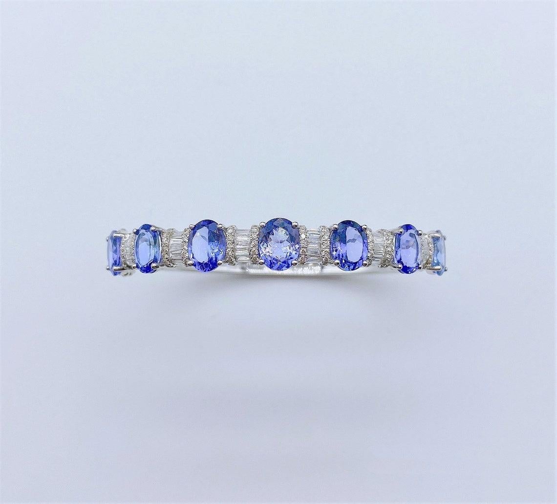 The Following Item we are offering is a Rare Important Radiant 18KT Gold Large Magnificent Rare Fancy Gorgeous Fancy Tanzanite and Diamond Bangle Bracelet. Bangle is comprised of Exquisite Fancy Oval Cut Intense Rich Tanzanites connected with
