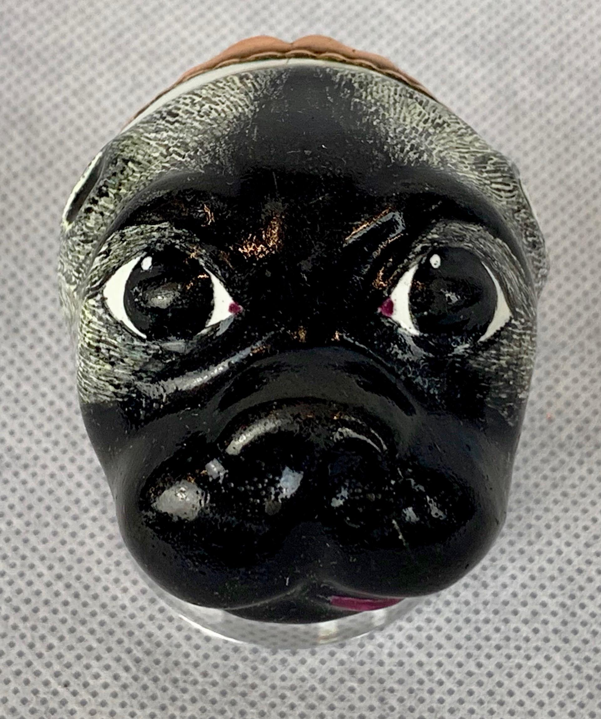 Rare 18th century Pug bonbonniere. Probably Bilston Battersea enamel on copper with a hinged cover. The pug is painted black with a bright pink tongue. The cover depicts a woman in a pink dress holding a rifle. The inside shows the same woman
