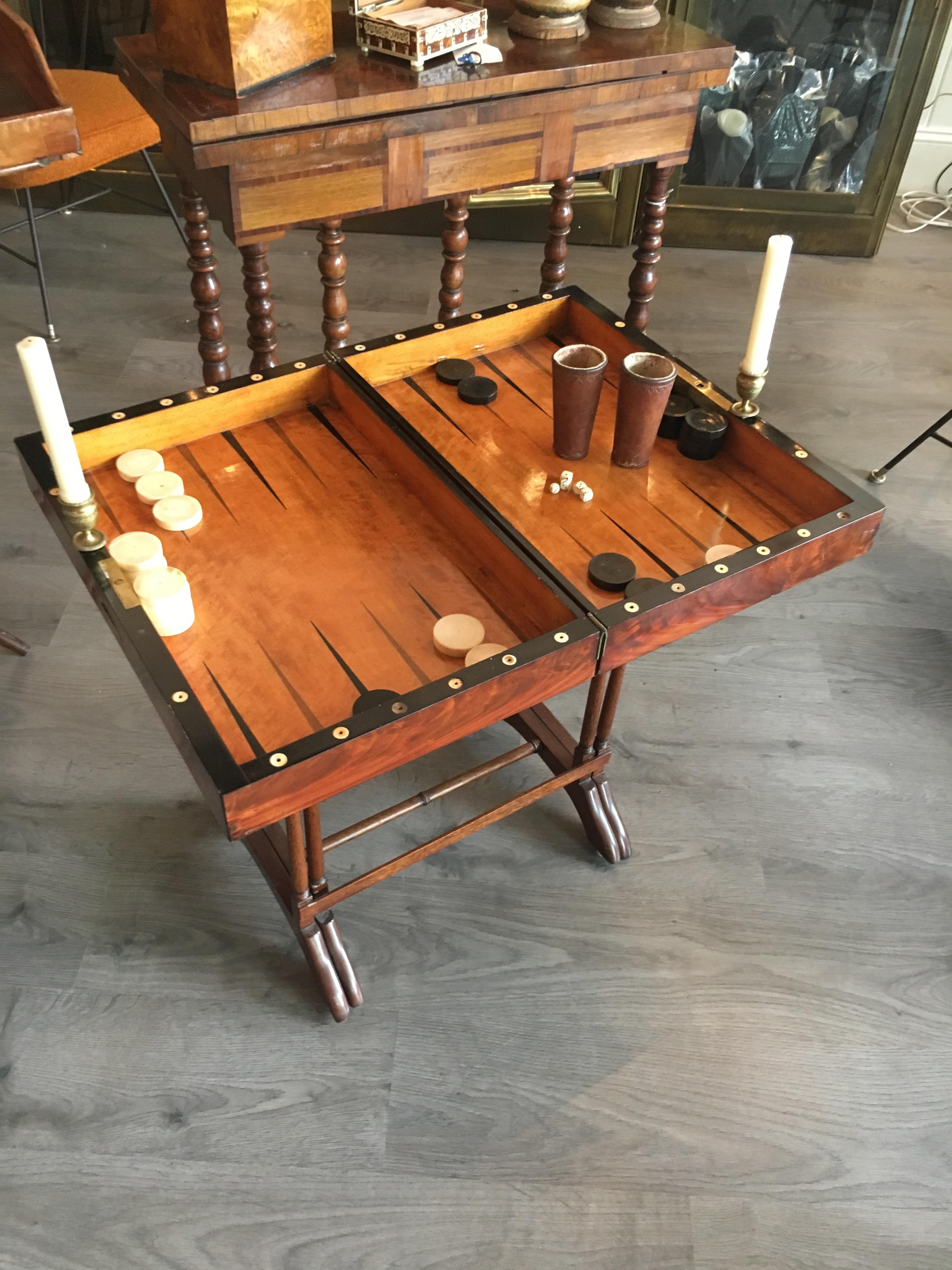 Rare 18th century English backgammon set with most of the original pieces on later stand. Mahogany, satin wood and ebonized. Original bone white chips, candle holders, dice cups with bone dice, replaced black chips. Later stand is Maitland smith.