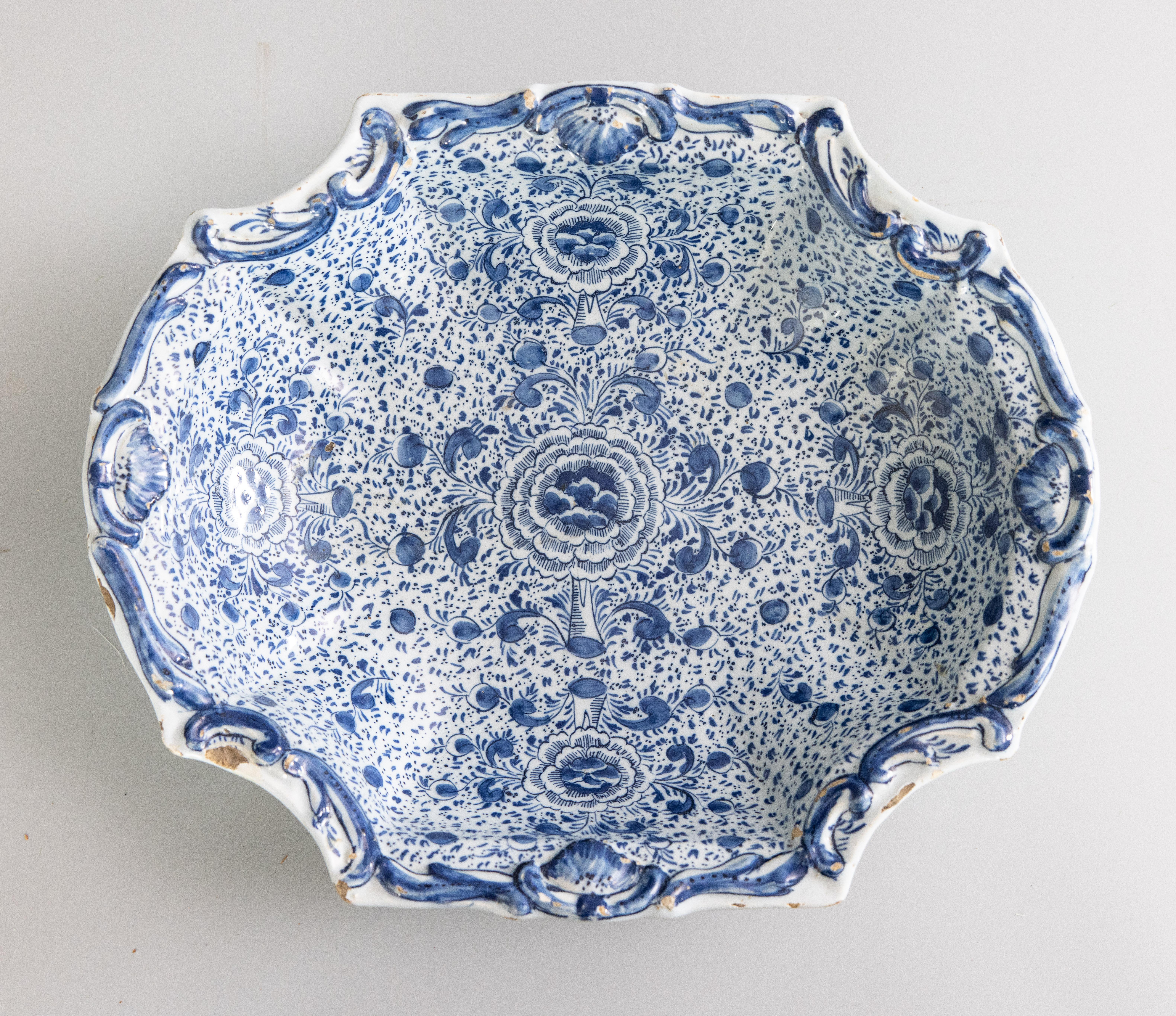A beautiful rare 18th century four-lobed Delft dish, decorated in blue monochrome with flowers and semi-circles in rocaille contours. Marked 