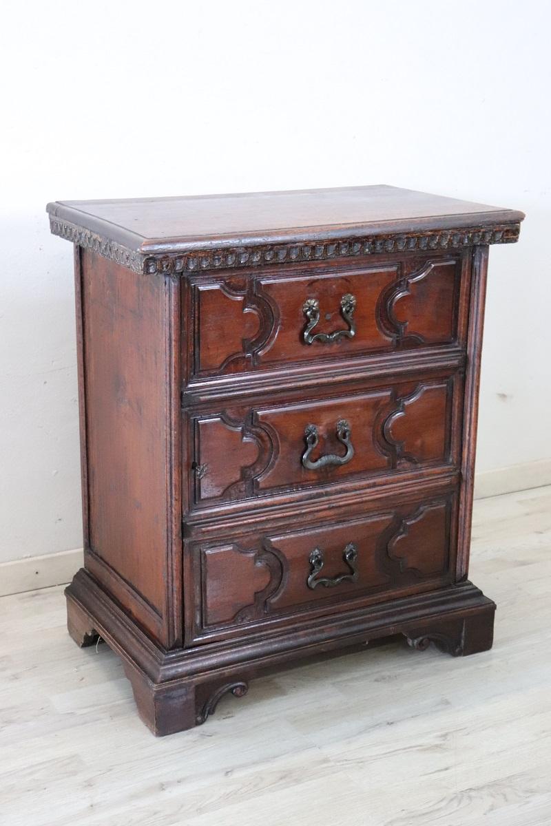 We present this rare and valuable Italian antique bedside table dating back to the first decades of the 18th Century.

Made of solid walnut wood and featuring a front with decorative panels. Its design line is typical of furniture from the Tuscan