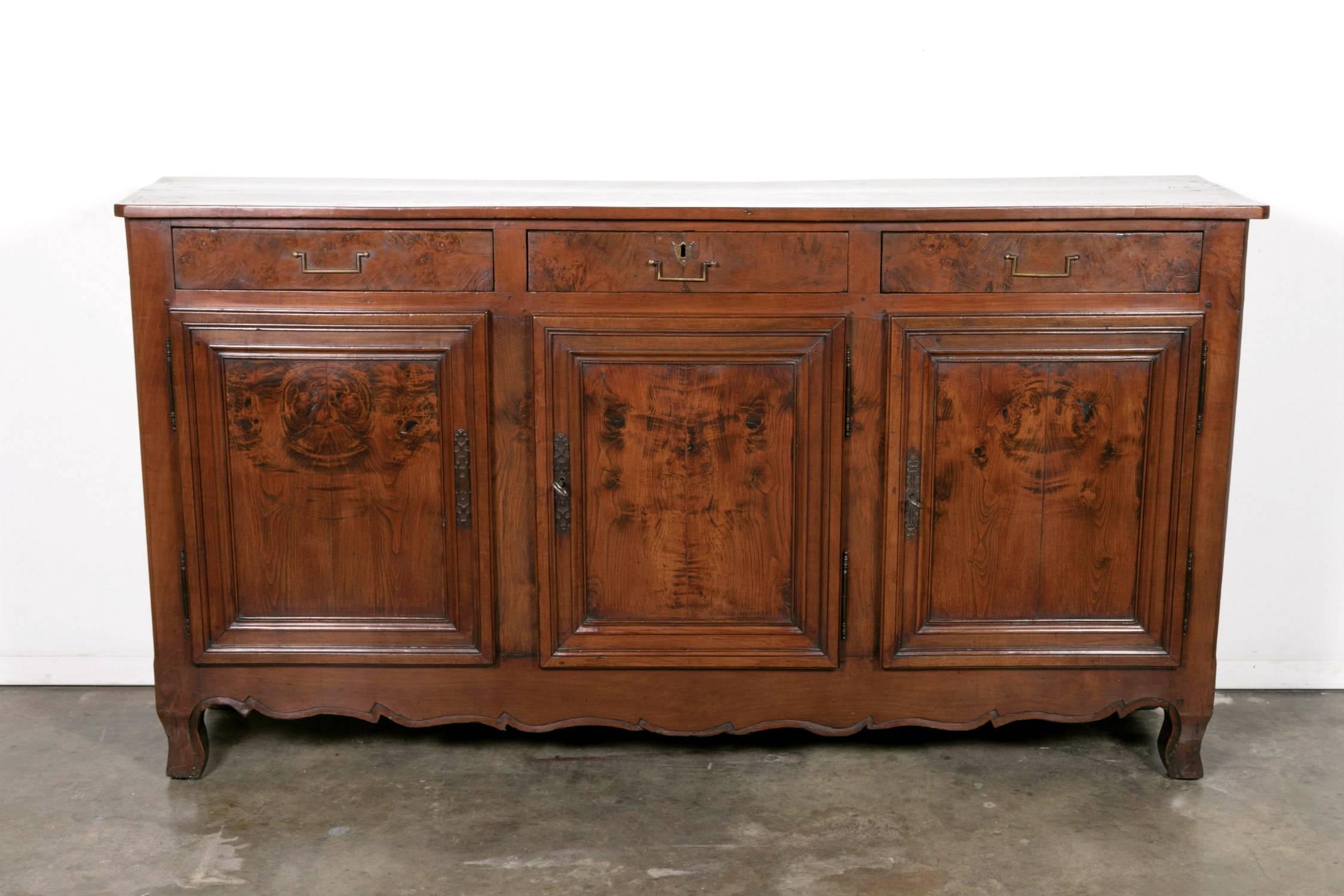 Handsome and rare 18th century cherry enfilade buffet with a burled chestnut bookmatched front having three drawers over three doors, handcrafted by skilled artisans from the Rhone-Alpes region during the French Transition period (1750-1775). Most
