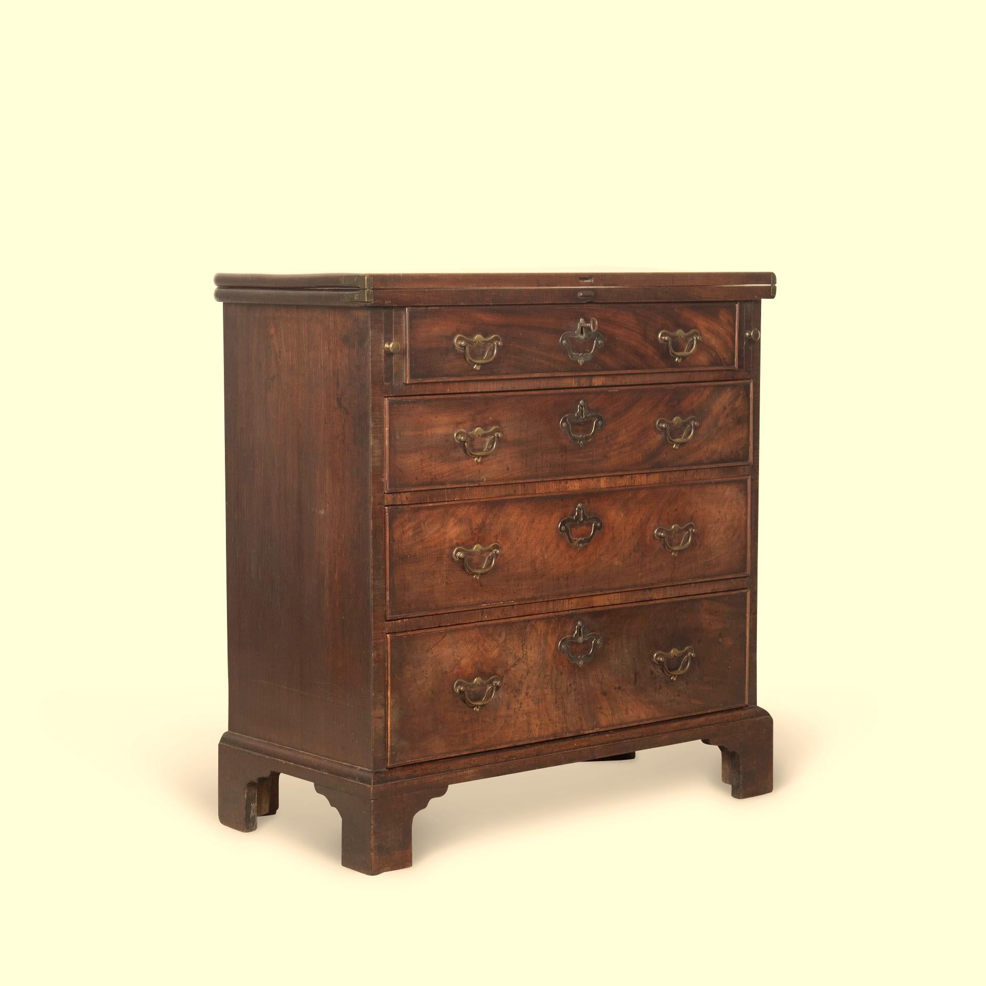 ﻿ A rare Geo III mahogany bachelors chest of small proportions, the fold over top with polished interior rests on pull out lopes, above an arrangement four graduating drawers with pierced brass handles and lock plates. All raised on bracket feet.