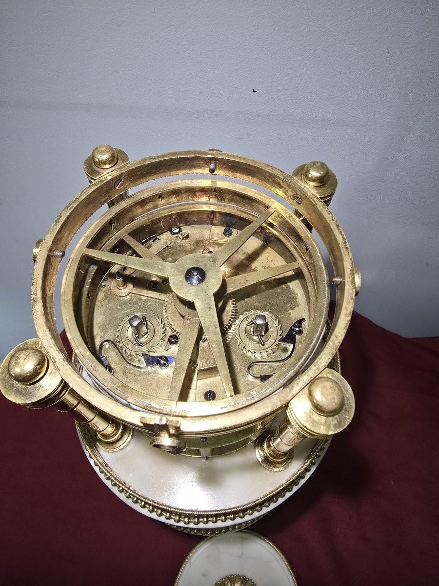 Prächtige Uhr im neoklassizistischen Stil aus dem 18. Jahrhundert, fein gearbeitet aus weißem Marmor und vergoldeter Bronze. In der Mitte steht ein Putto unter einem eleganten Baldachin, der von vier Säulen getragen wird. Dieses raffinierte Modell