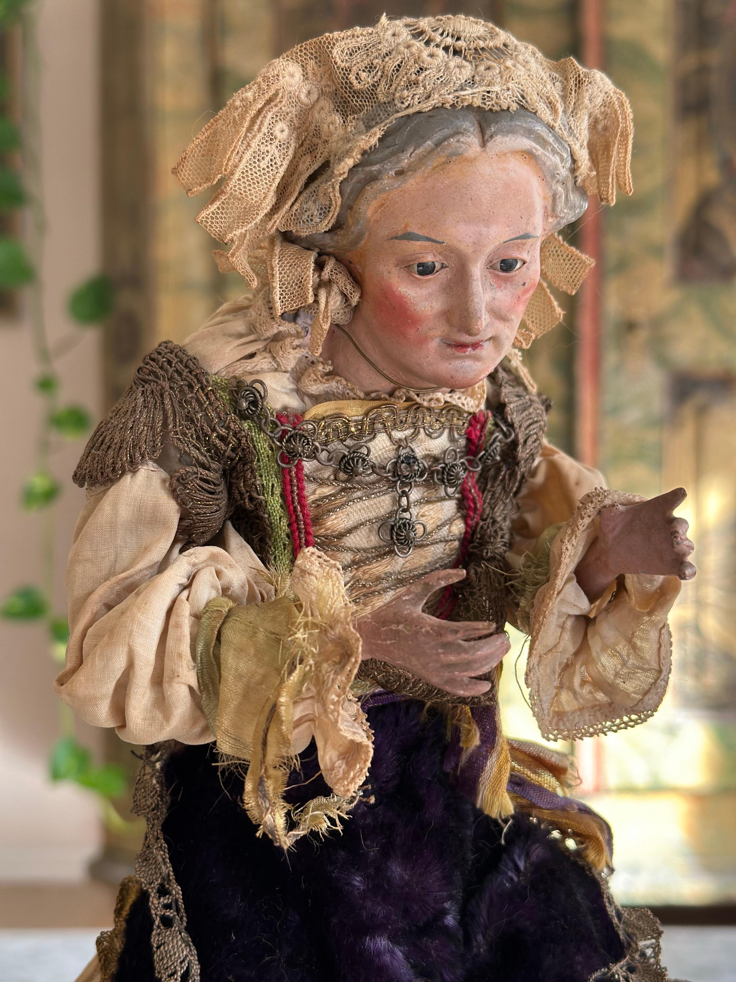 This rare, antique Neapolitan nativity figure from the 18th century represents a woman in traditional dress with a distinctive head covering, a vivid example of the skill and cultural richness of Neapolitan craftsmanship. Originating from Naples,