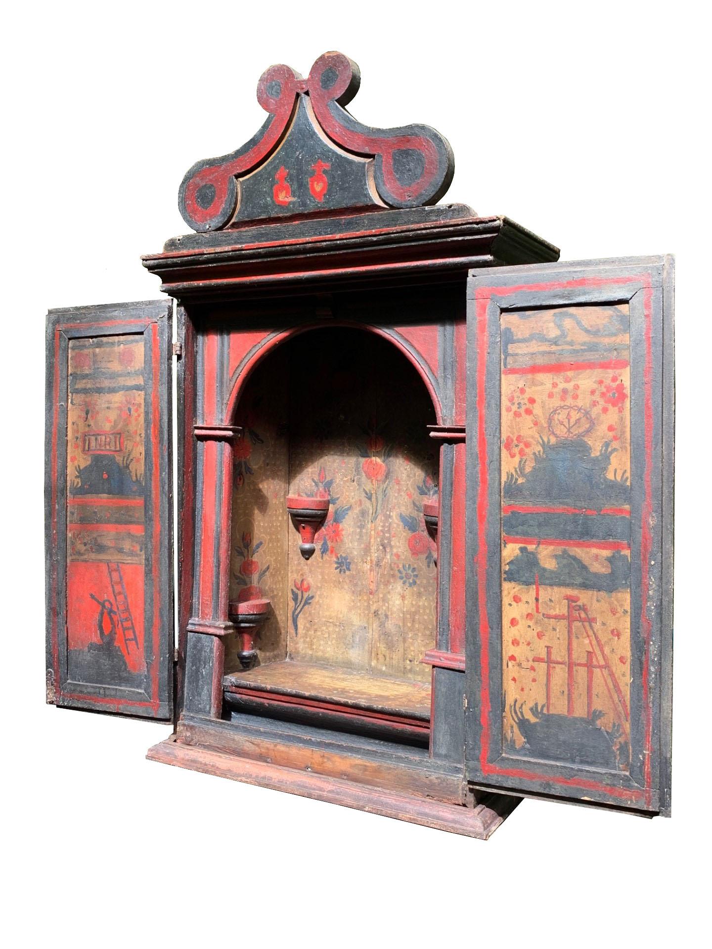 Ce magnifique sanctuaire brésilien du XVIIIe siècle, originaire du Minas Gerais, est un exemple stupéfiant de l'artisanat religieux baroque colonial. Fabriquée en bois et ornée de motifs peints à la main, cette pièce comporte des portes doubles qui