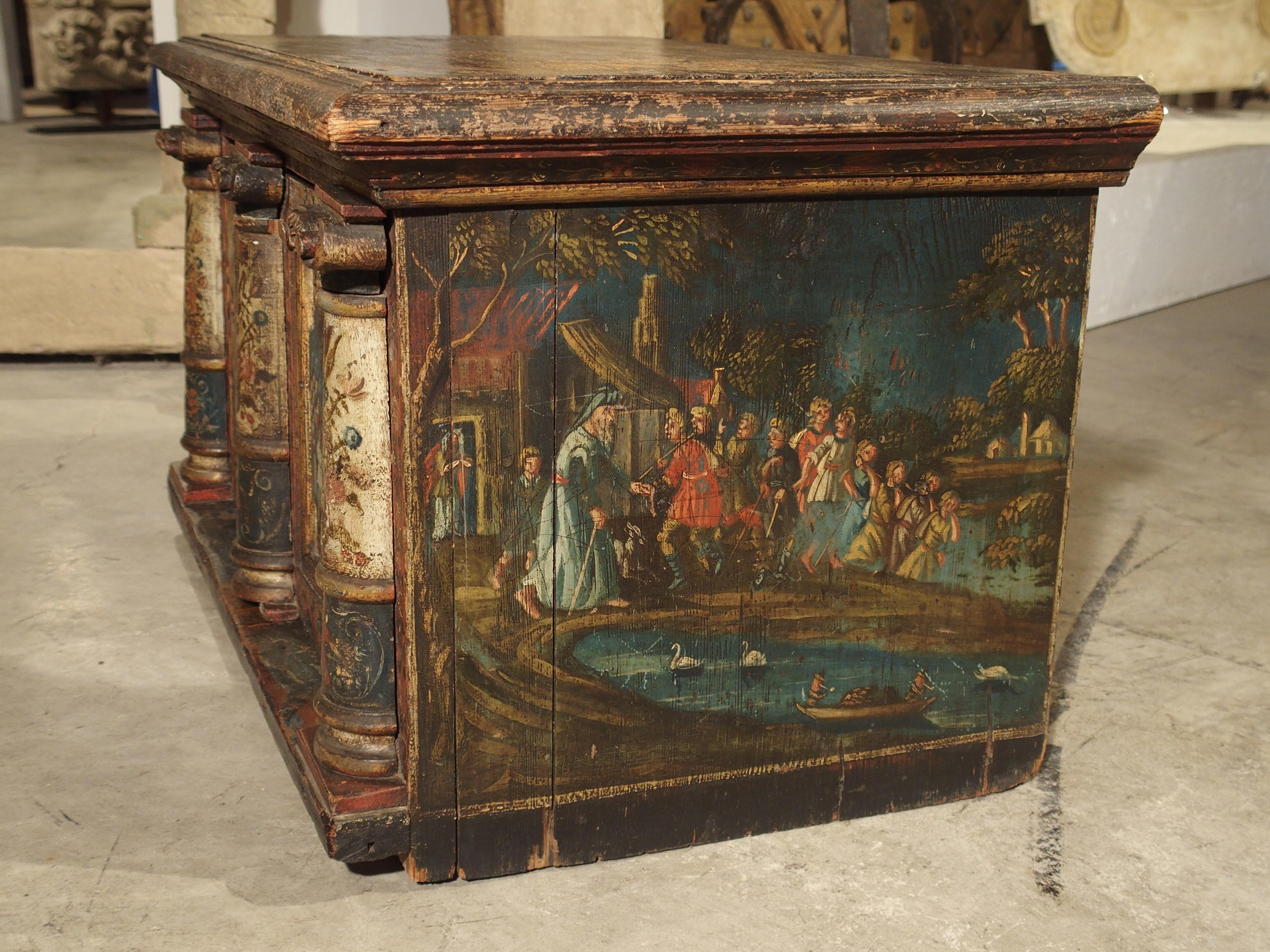 This rare and colorful pine wood table cabinet from Southern Germany dates to the 1700s or quite possibly older. Pieces of this type that survive today can date back to the 14th century. This piece has a front opening door with three pilasters