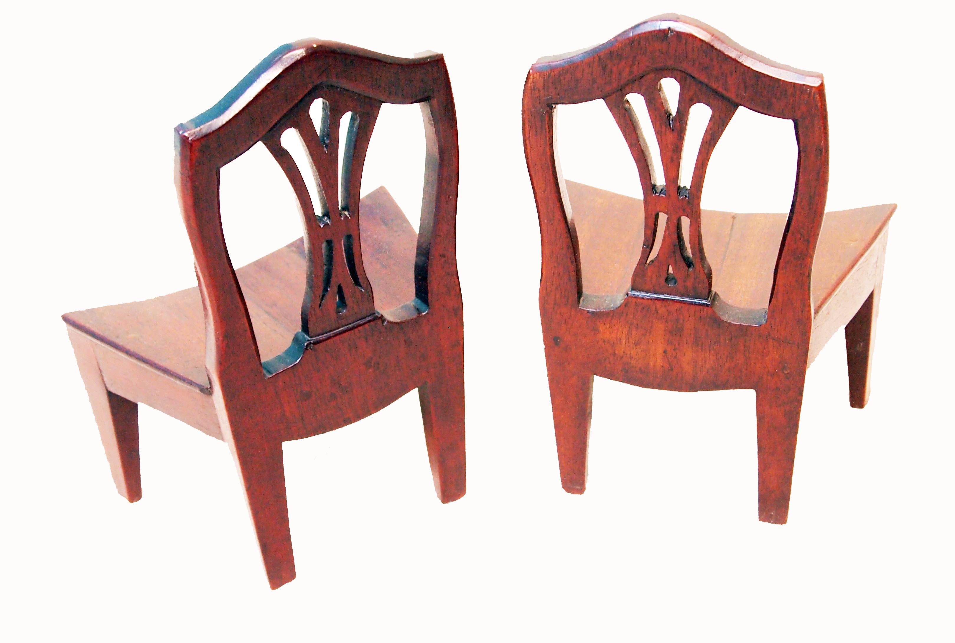 A very rare pair of 18th century mahogany miniature chairs
Having pierced splat backs and unusual bowed seats raised
On square tapered legs

(These are a most unusual example of 18th century Georgian 
miniature furniture. They are beautifully