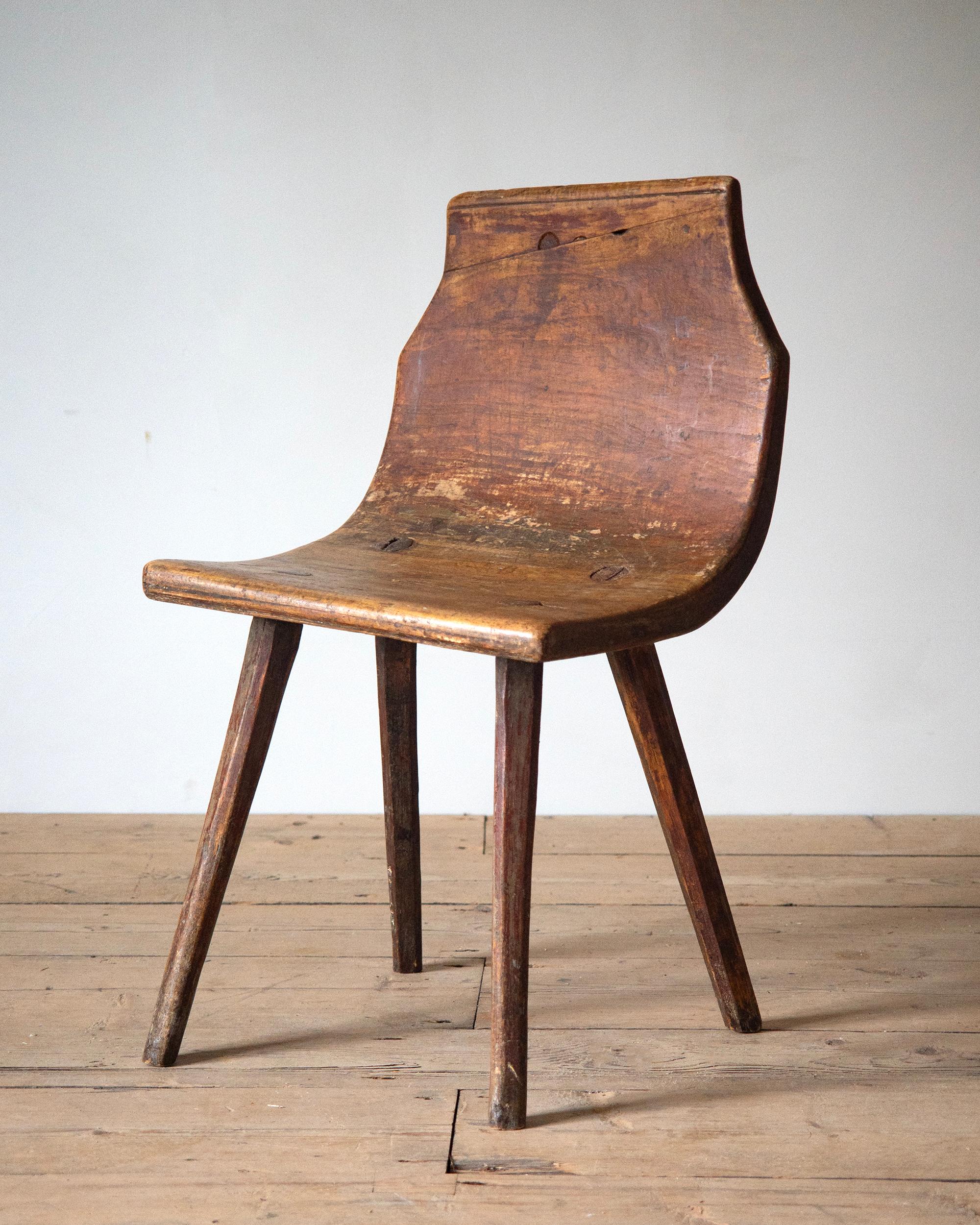 Rare 18th century Swedish Folk Art chair with an curved one solid piece of wood for the seat and back. The finish is original. Ca 1790 - 1800 Sweden. 