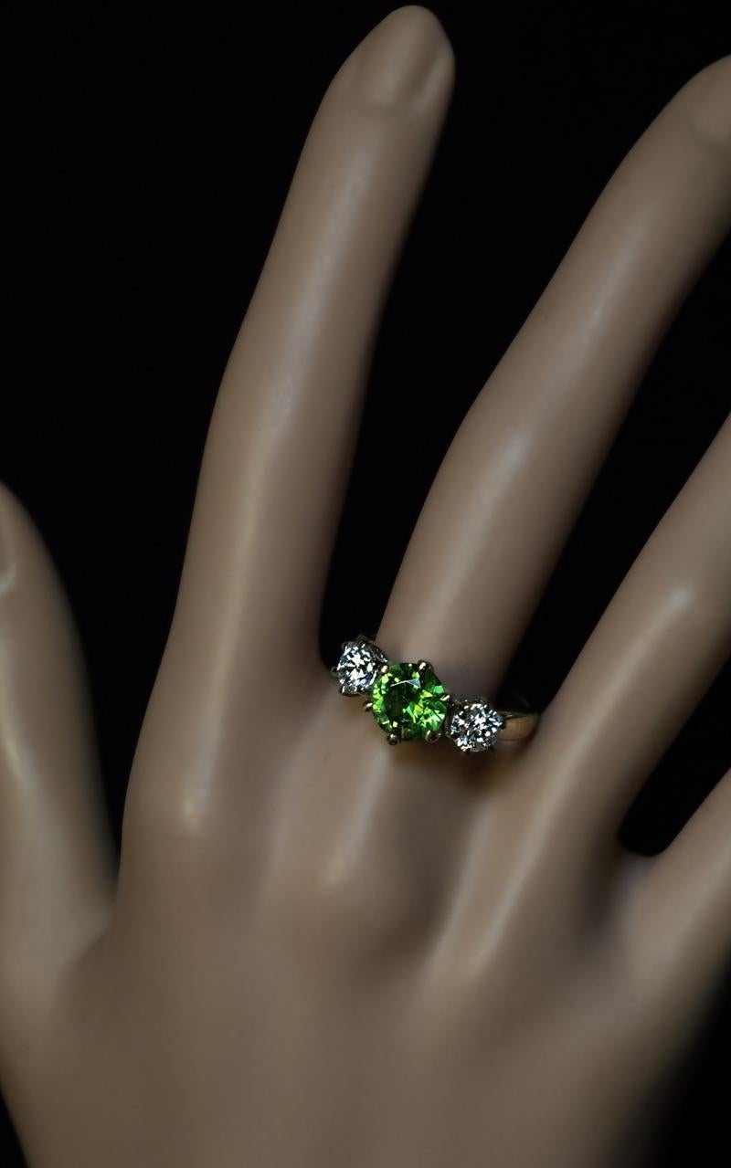 This contemporary three stone 14K yellow and white gold ring features an excellent 1.90 ct Russian demantoid from the Ural Mountains. The demantoid is flanked by two bright white diamonds (0.50 ct and 0.52 ct, G-H color, VS2 and SI1 clarity).

The