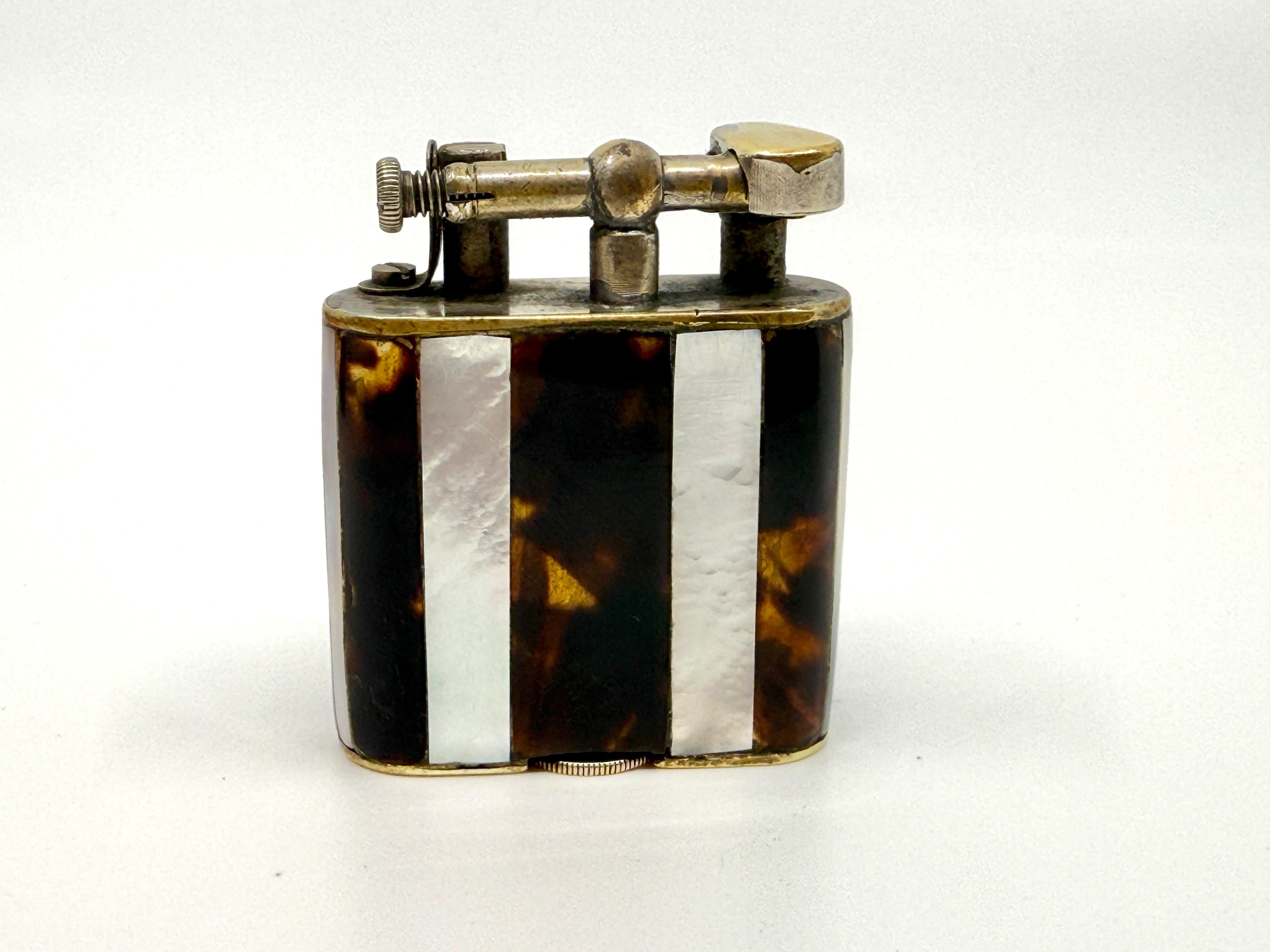 A wonderful early Dunhill Unique Lighter with Mother of Pearl and Horn decoration. The Unique lighter series are special and this is a working beauty. The lift arm design works well and it sparks and lights as you can see in the photos. There is