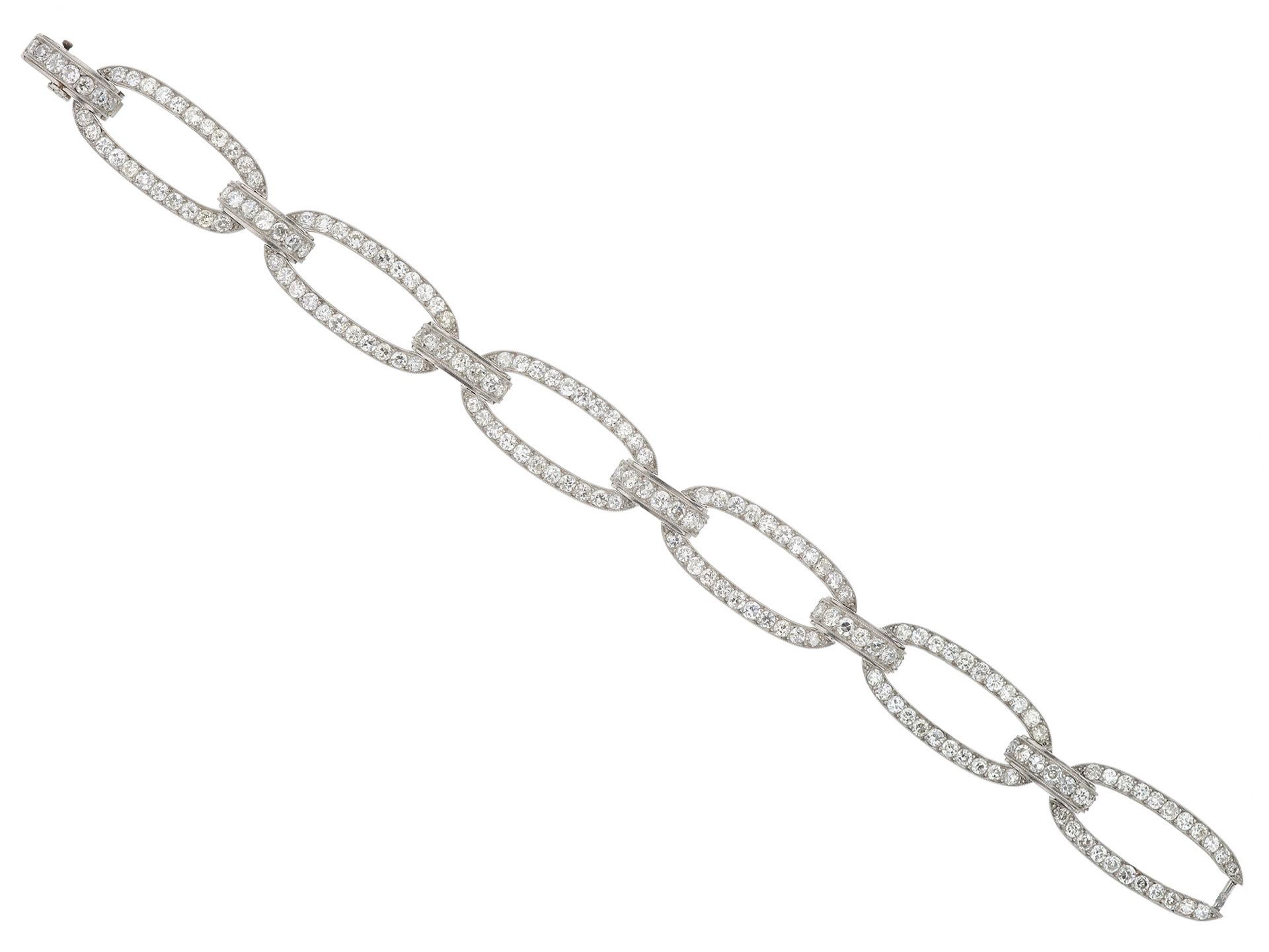 Diamond bracelet by Georges Fouquet, French, circa 1920. A platinum bracelet composed of six oval links joined by six curved bar shaped links including an integrated clasp, set with one hundred seventy four round old cut diamonds in millegrain bead