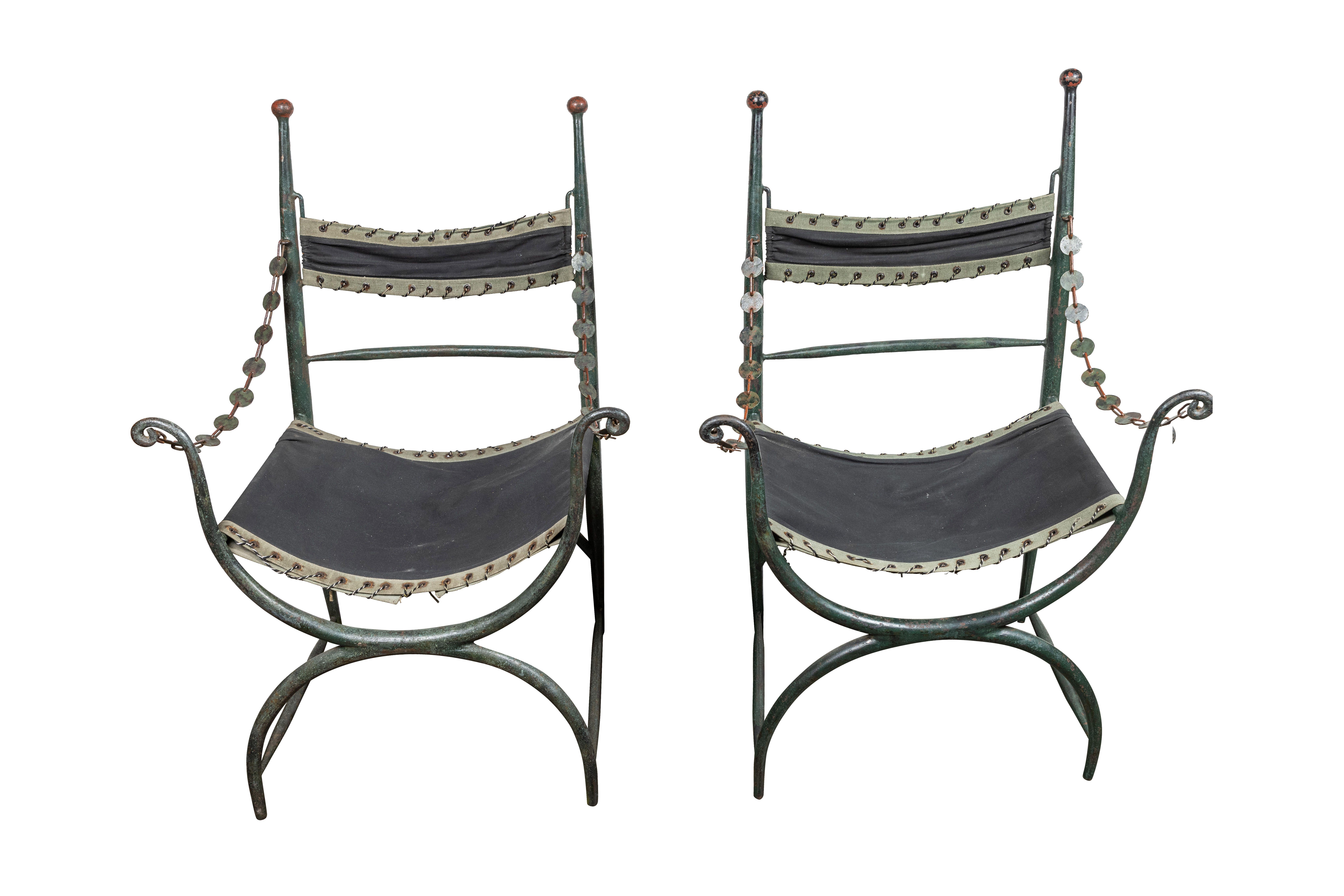 A chic, exceedingly unusual pair of hand-painted, hollow, cast iron armchairs with hand-punched, swing arm, chain garlands. The back rails are surmounted by sphere finials, and forward arms are scroll form. The whole above curved- x-form bases. The