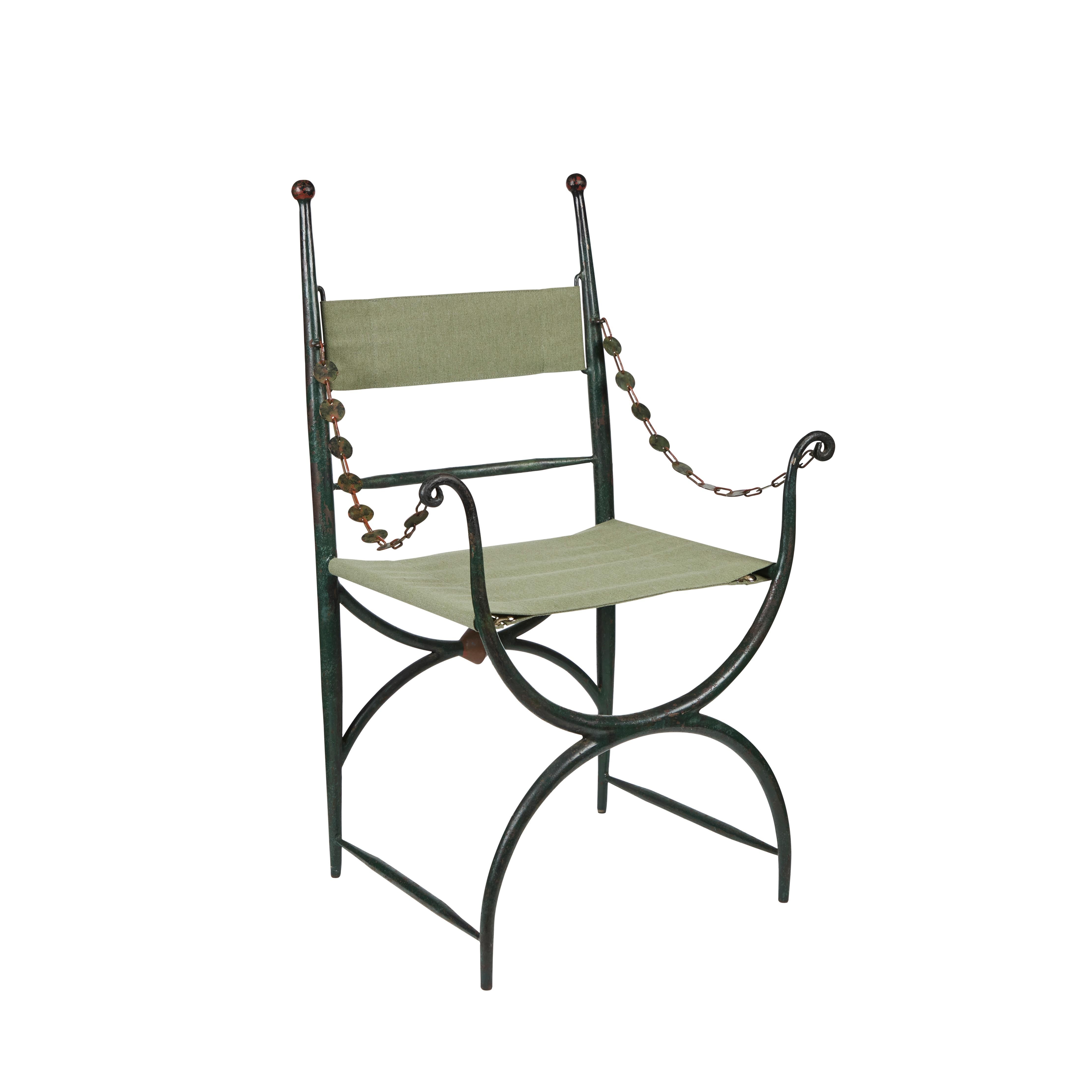 A chic, unusual pair of hand-painted, hollow, cast-iron armchairs with hand-punched, swing arm, chain garlands. The back rails are surmounted by sphere finials, and forward arms are scroll form. The whole above curved- x-form bases. The chairs have