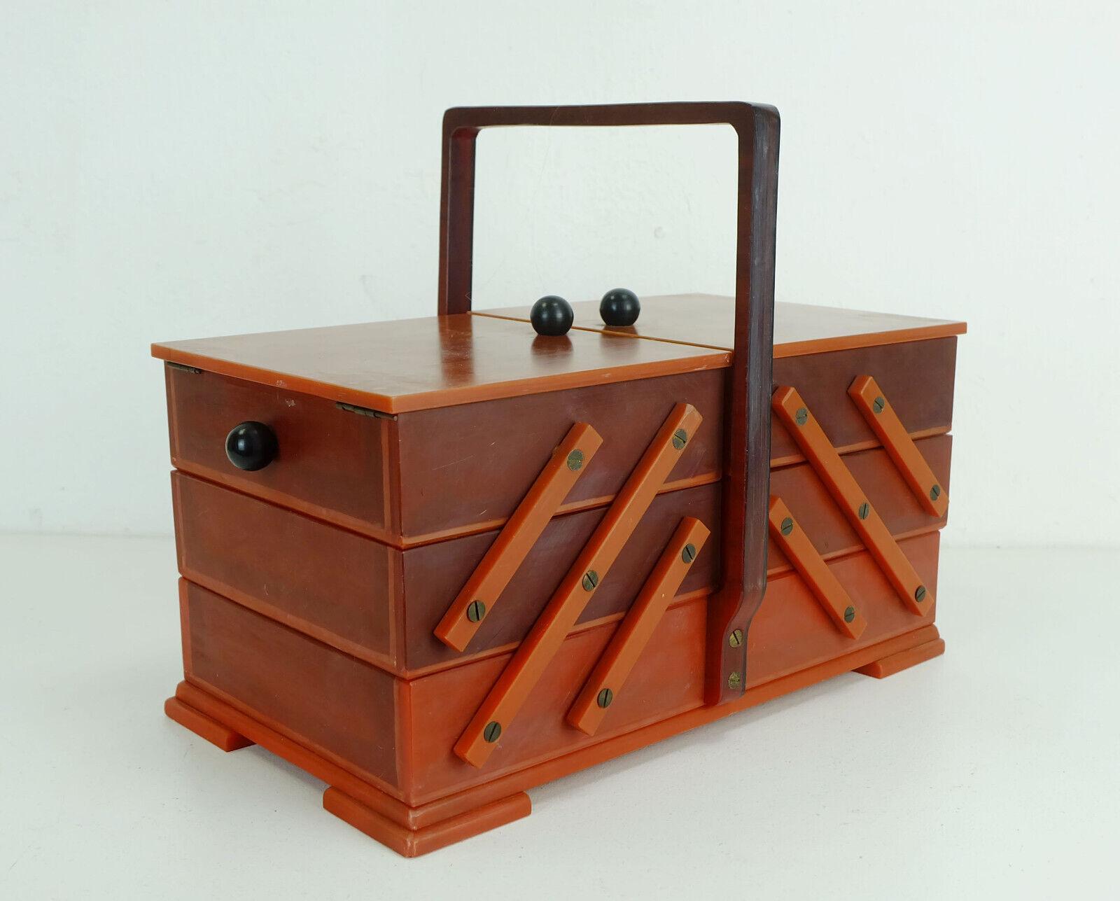 Rare pull-out sewing box from the 1930s / 40s. It is made entirely of celluloid with brass hinges. Very nice collector's item, rare to find in this material. 

Very good condition, no damage, color differences due to the effects of