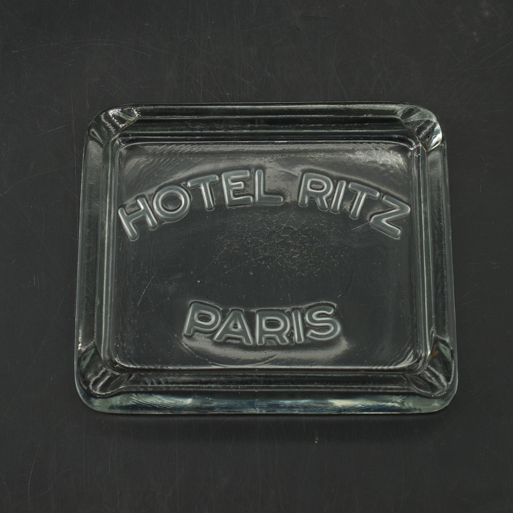 An Art Deco glass ashtray souvenir from the 1930s and 1940s Hotel Ritz, Paris. A chic table-top accessory that might imply you were at the world's best hotel over 50 years ago. Measures: W 4.13 x D 3.38 x H .75 in.

 