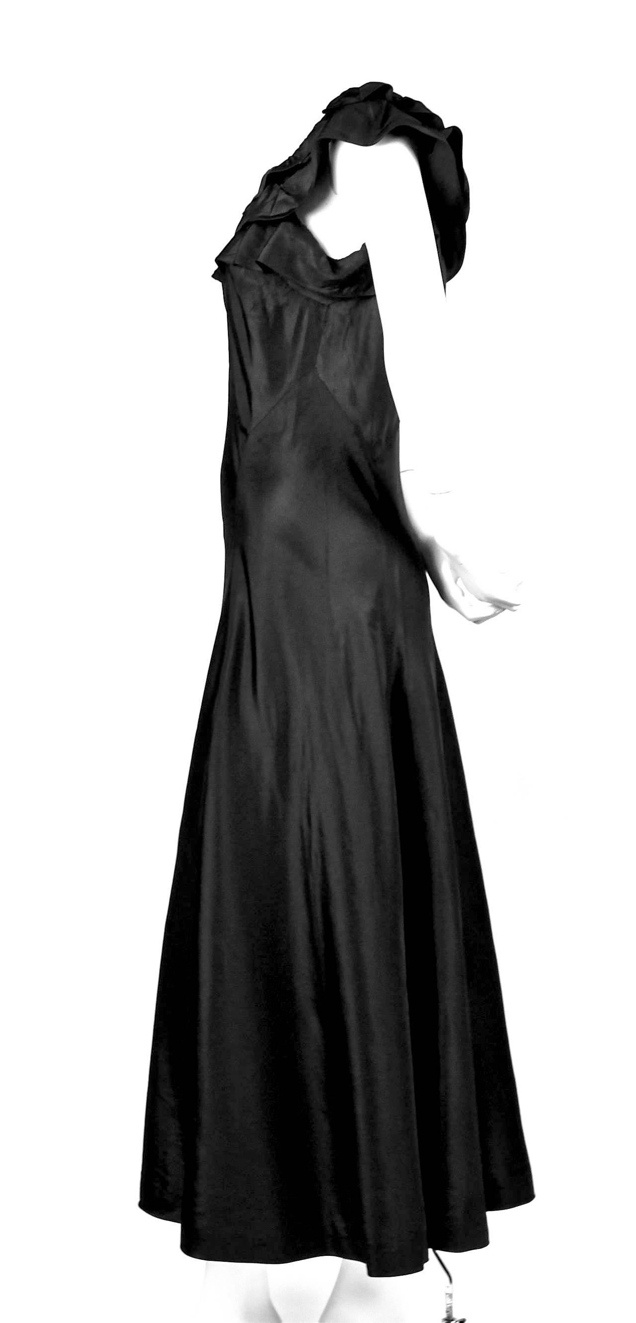 Extremely rare haute couture dress made of black taffeta with a bias cut designed by Jeanne Lanvin dating to 1933. Unique ruffled neckline and empire waistline. Dress slips on over the head with no zippers or closures. Hand finished seamed