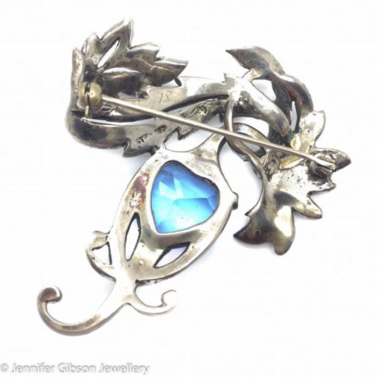 A superb and rare solid sterling silver Boucher heart brooch dating to the 1940s. Laden with tiny paste stones around a central heart shaped delicate blue crystal stone. The design and flowing lines of this piece scream the very best of Boucher