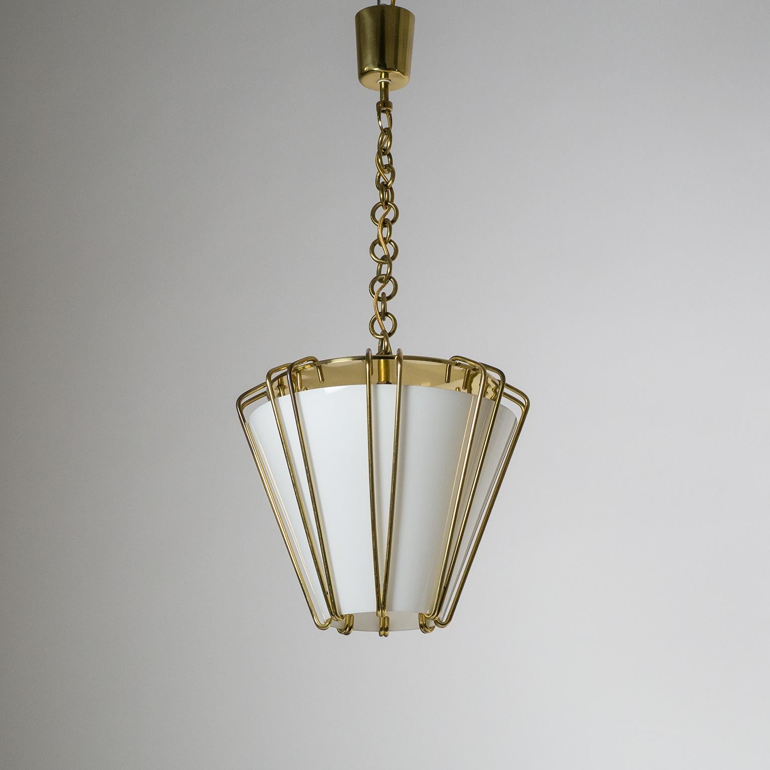 Brilliant and rare J.T. Kalmar lantern or pendant from the 1940s in brass and glass. The large conical glass diffuser (with white inner casing) is suspended by an ingenious design of brass wires. Extremely good original condition with some light