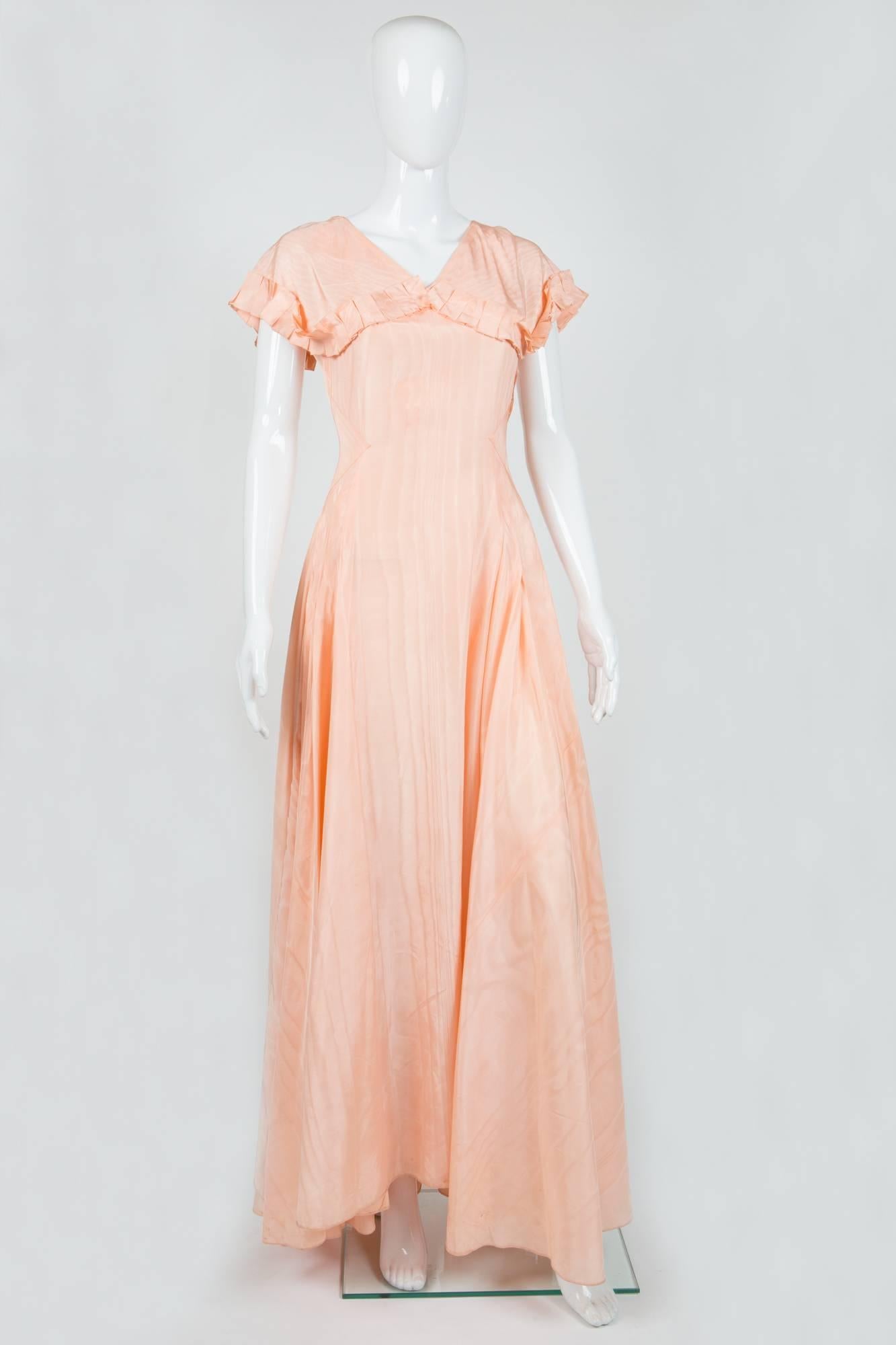 Gorgeous 1940s peach pink silk dress featuring maxi length,  fixed flounces on front bust & goes on back sleeves, bias cut with many tailoring details, maxi length.
In good vintage condition ( a small mini hole at back). Made in France.
Estimated