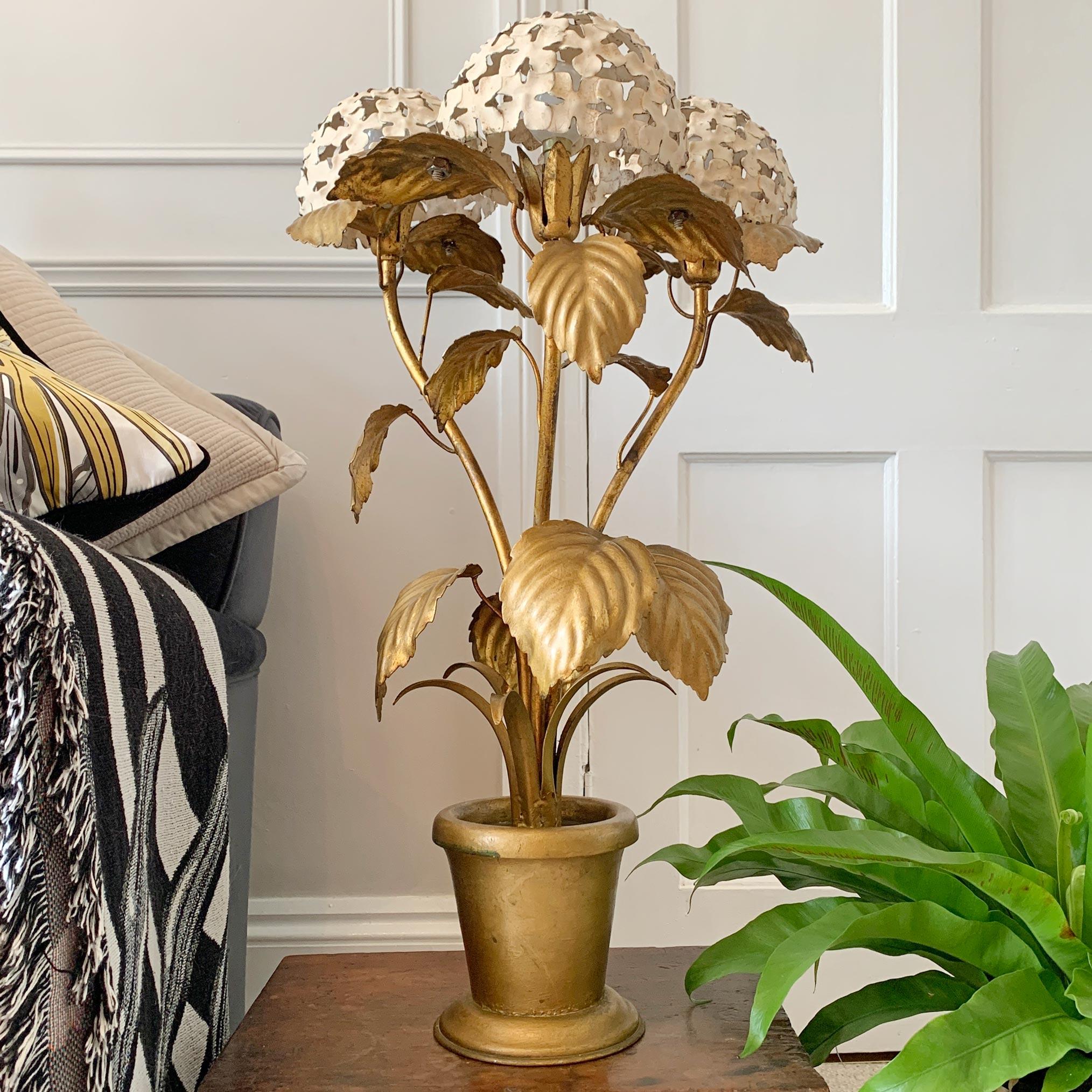 A rare 1950s American Hydrangea table lamp. The gold painted leaves and flower stems housed within a golden pot, each of the three off white Hydrangea flower heads has a wonderful craquelere finish, with each housing a single small bayonet (B15)