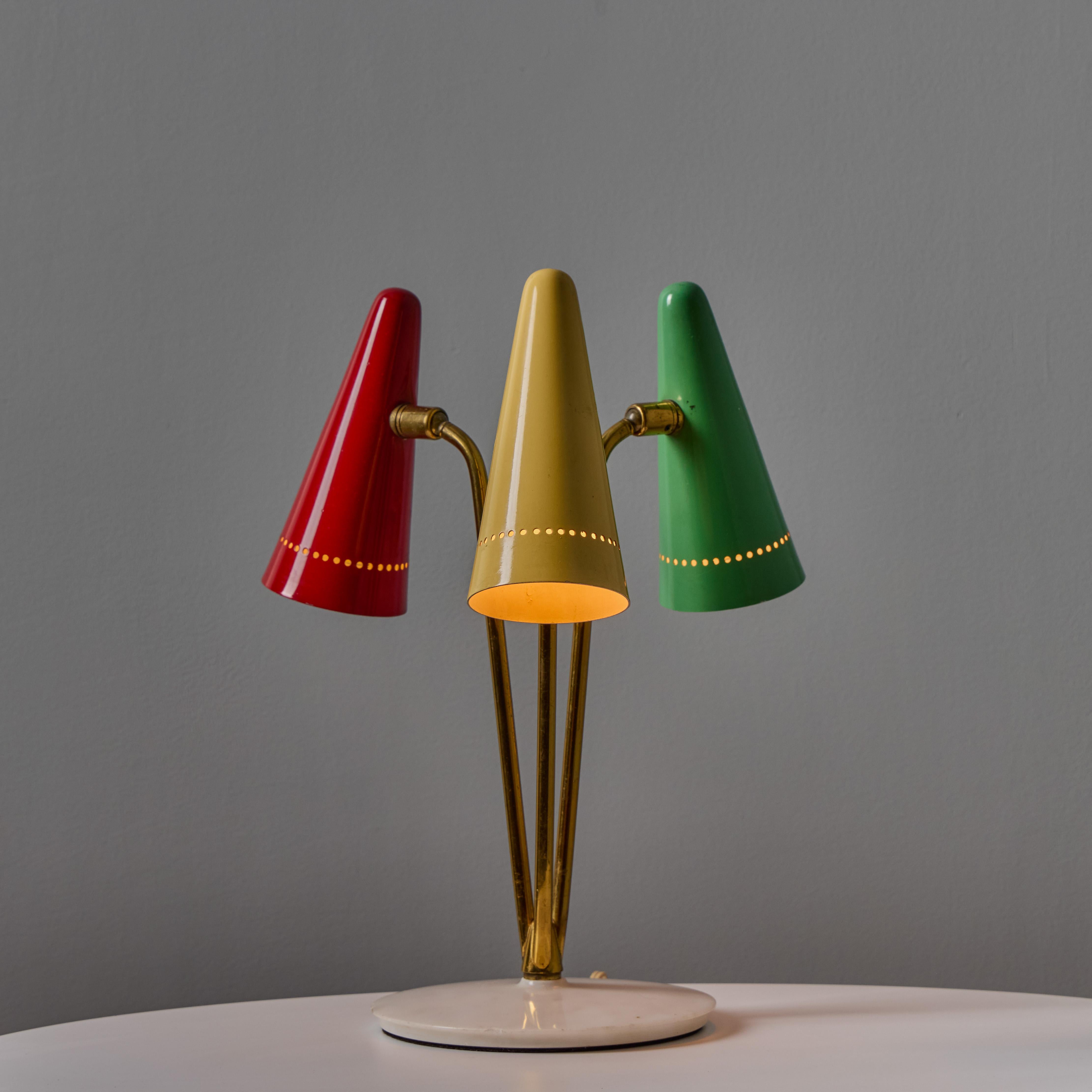 Rara lampada da tavolo a 3 paralumi multicolore di Angelo Ostuni per O-Luce del 1950. Un design estremamente raro e giocoso realizzato in ottone e metallo verniciato da uno dei più raffinati designer italiani della metà del secolo scorso. Ogni