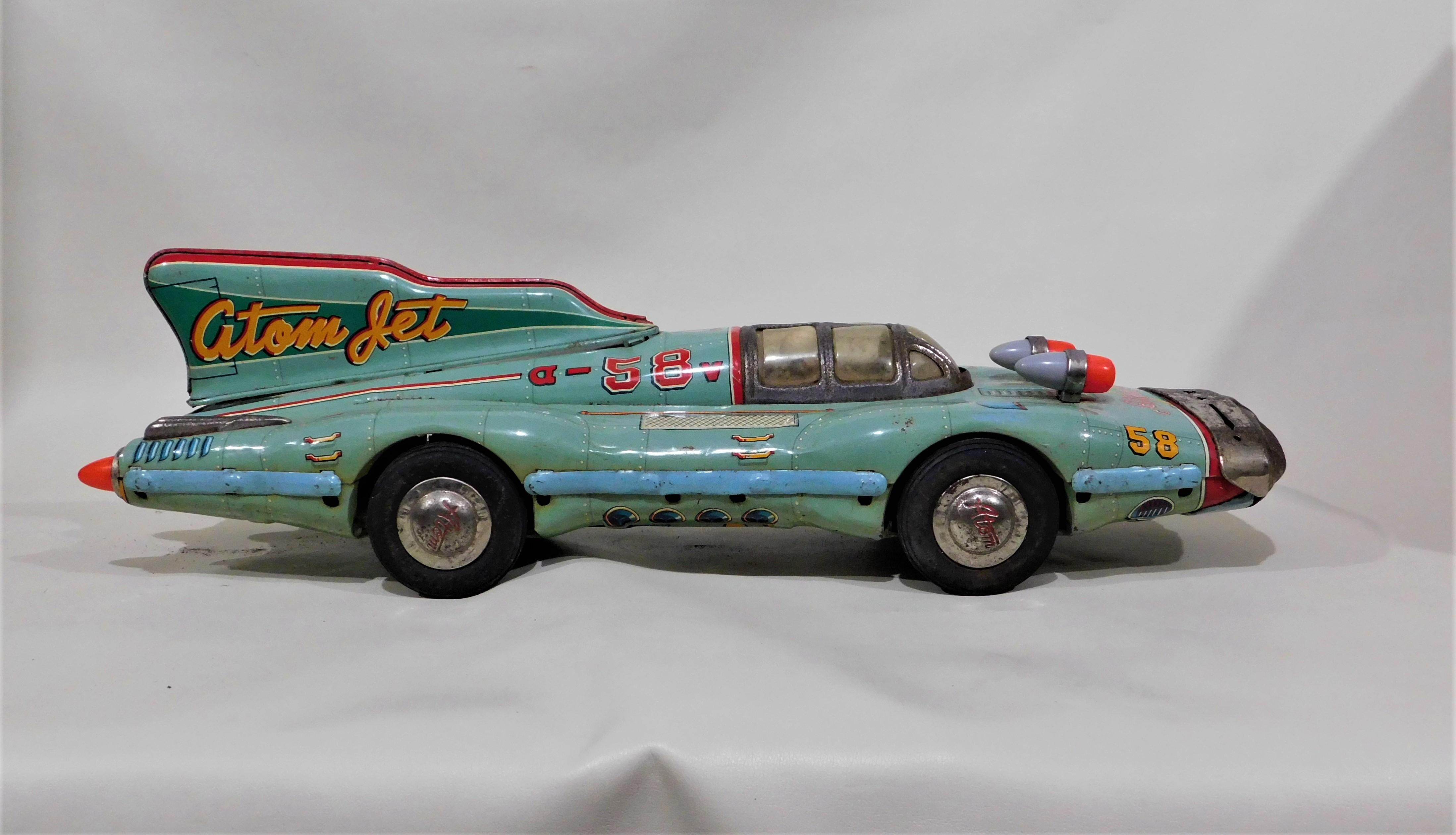 Rare 1950s Atom Jet very large tin litho friction race car made by Yonezawa Japan, over 2 feet long (27 inches).
With its futuristic space age atomic Japanese design, this is one of the most sought after tinplate toys, with all original parts, top