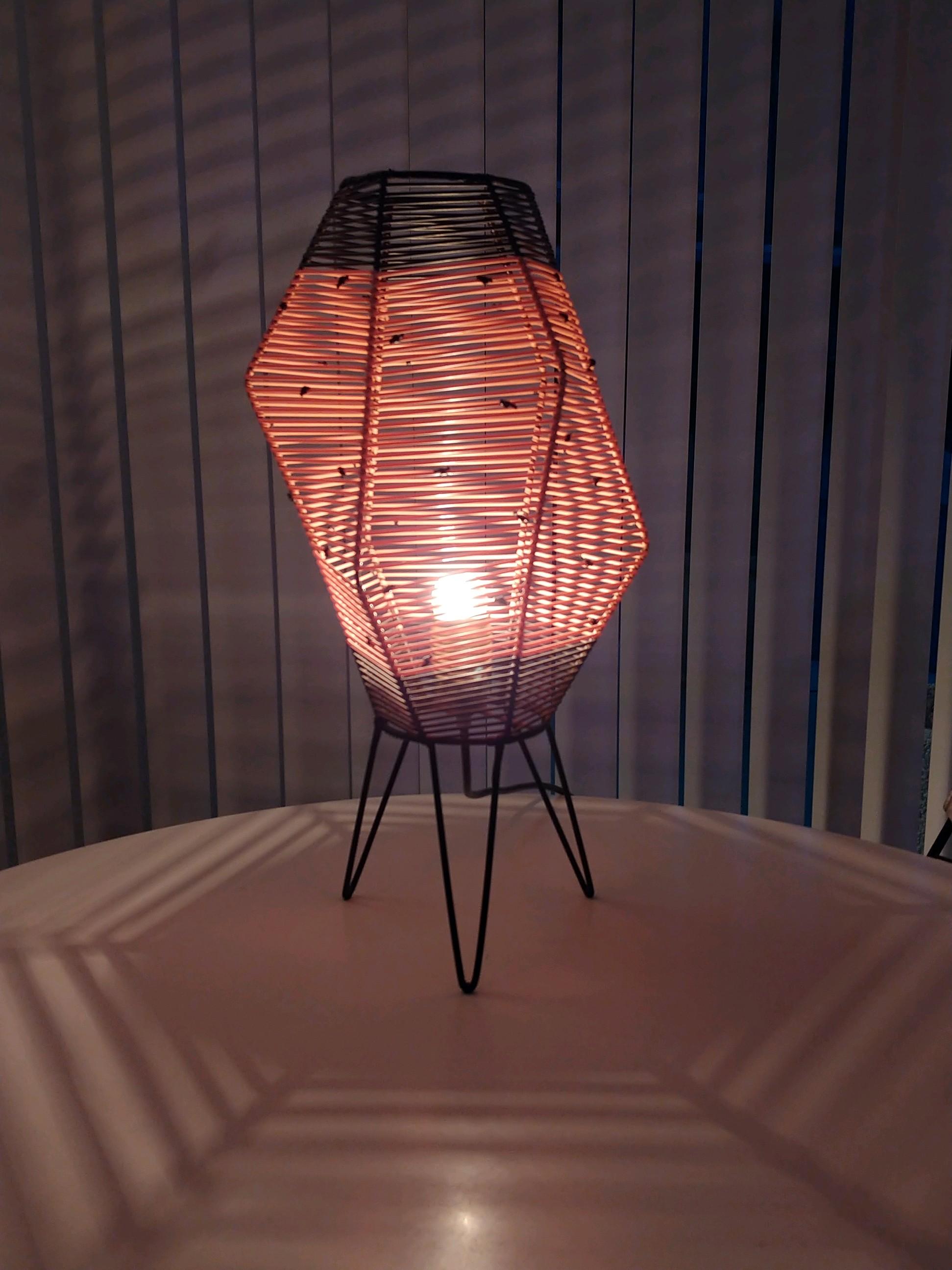 This asymmetrical wire frame lamp with hairpin legs is wound with pink and black nylon cord. When used with a clear bulb the light creates patterns on the table and on the walls. Nylon cord is 100% with no losses or damage. This lamp was found in