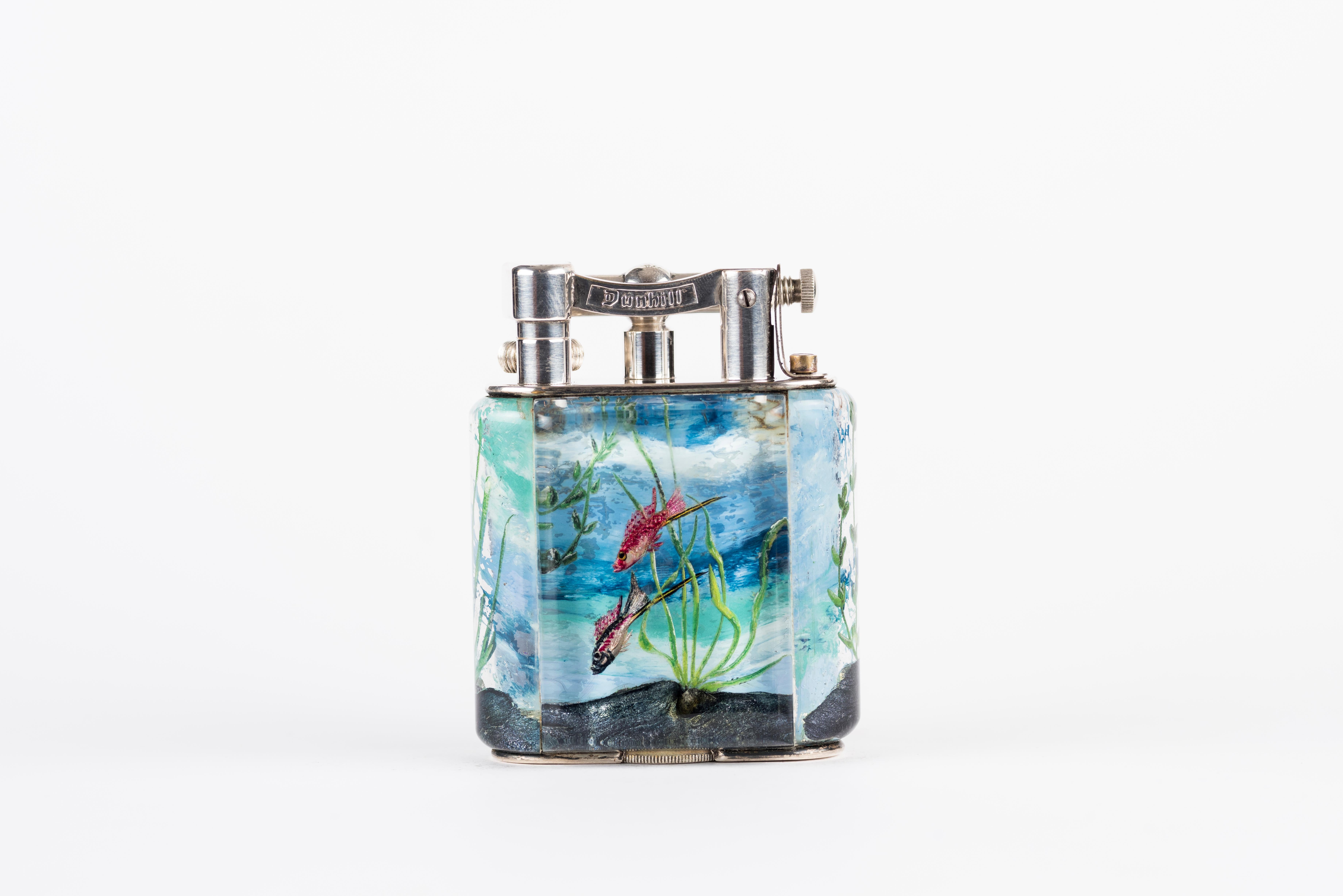 A rare 1950s Half-Giant Dunhill Aquarium table lighter (made in England) with silver-plated metal work 
Each of these lighters are very rare and unique as they were hand carved and painted and no one look exactly similar.

Ben Shillingford