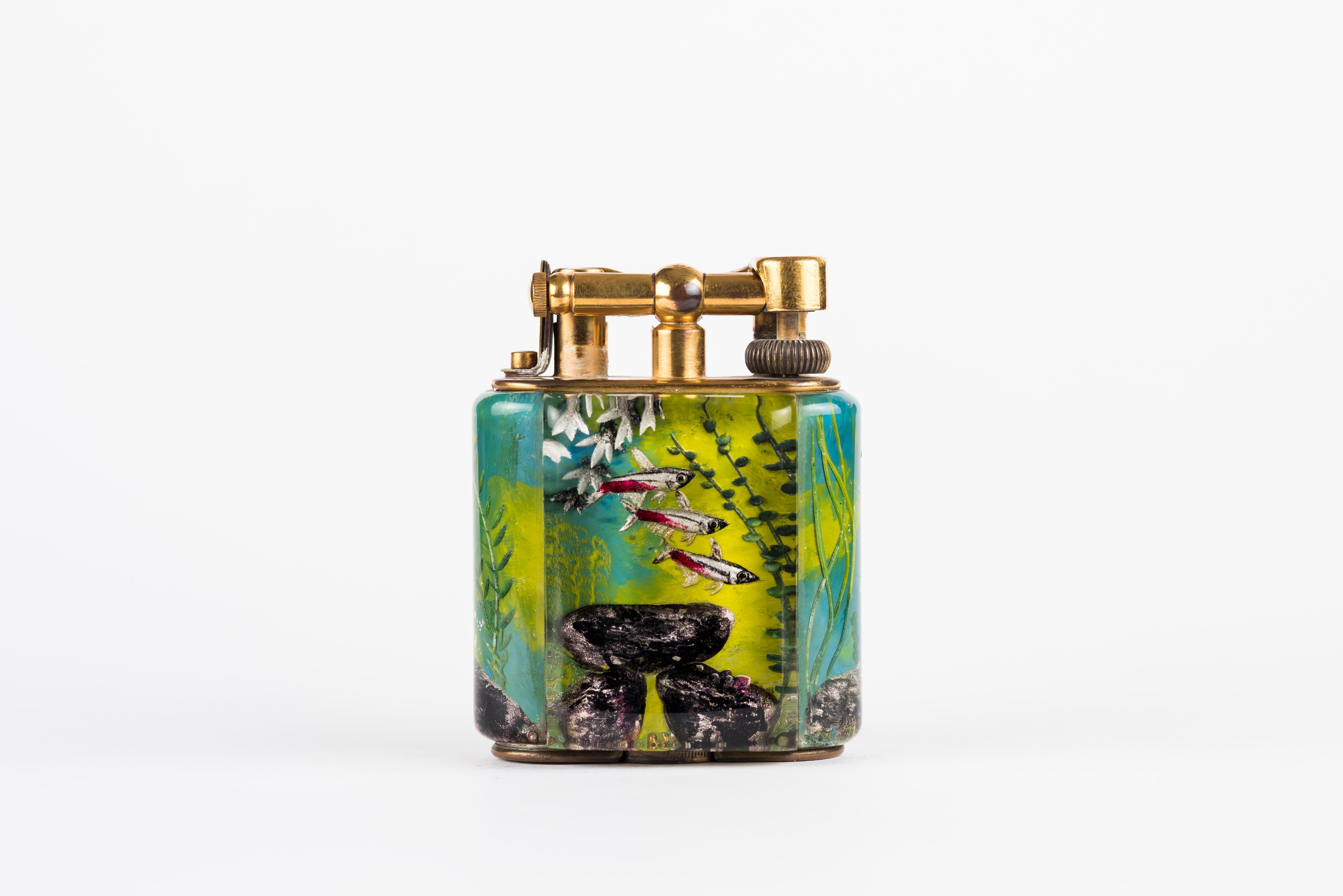 A rare 1950s Half-Giant Dunhill Aquarium table lighter (made in England) with silver-plated metal work 
Each of these lighters are very rare and unique as they were hand carved and painted and no one look exactly similar.

Ben Shillingford