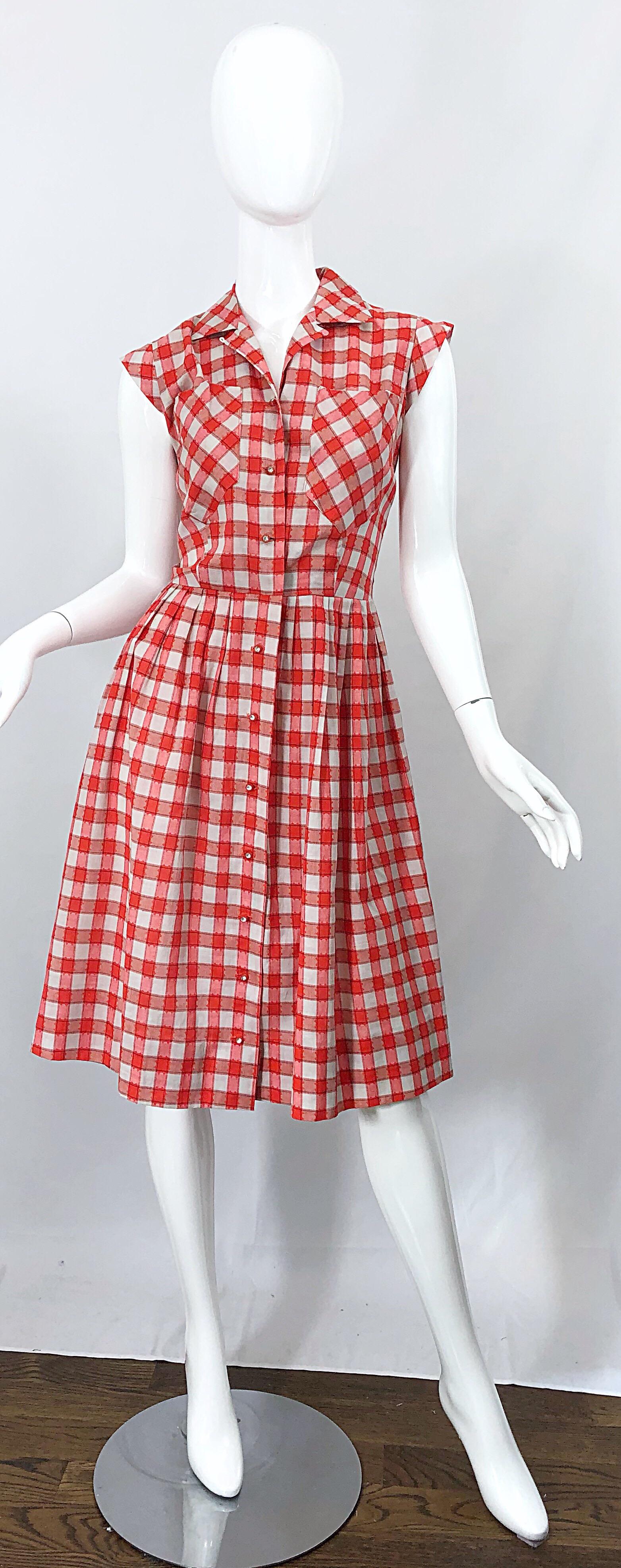 Chic and rare early 1950s cotton dress! Features a fitted bodice with a forgiving full skirt. Rhinestone encrusted buttons up the front, with hidden hook-and-eye closure at left neck. Pocket at each breast. Great belted or alone with wedges, sandals