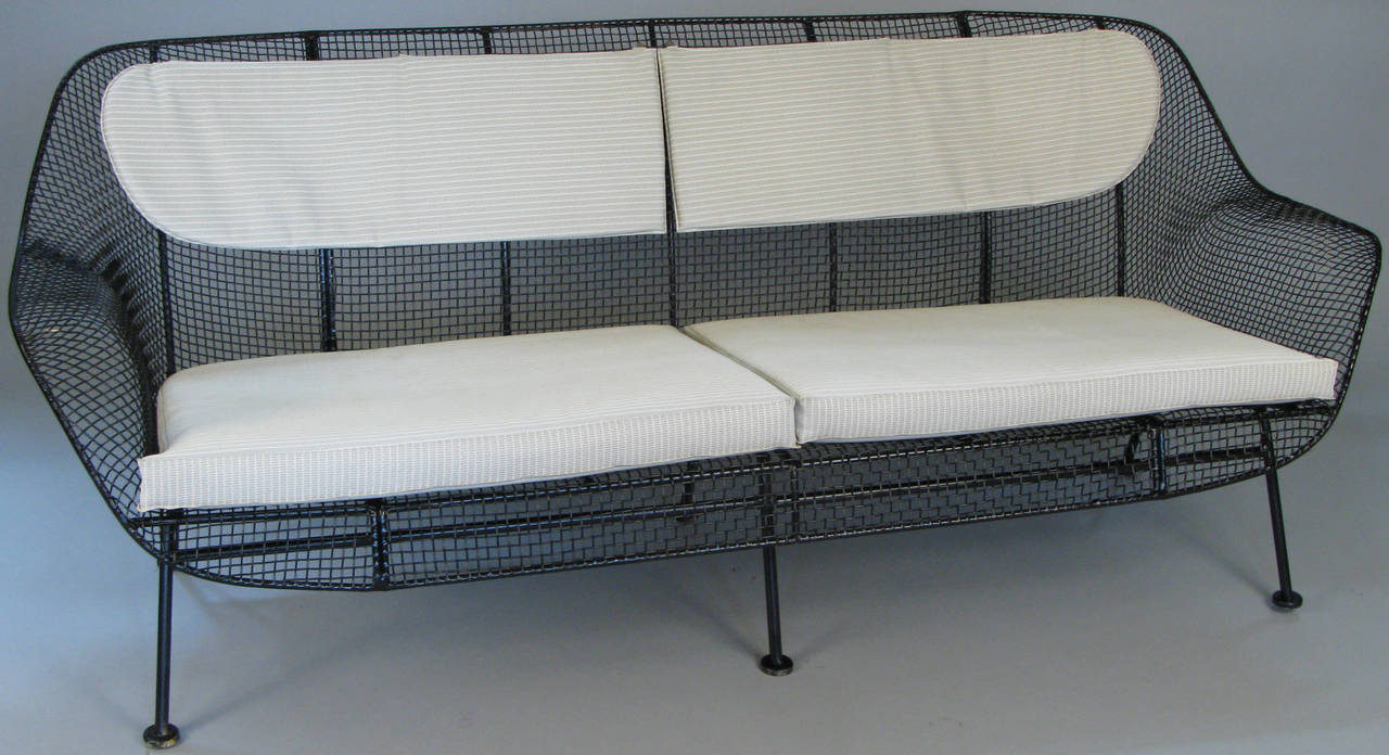 A rare example of Russell Woodard's iconic sculpture long sofa in wrought iron and woven steel mesh. Beautiful proportions in this wide and deep lounge sofa make this very comfortable and stylish. Finished in satin black or can be finished in color