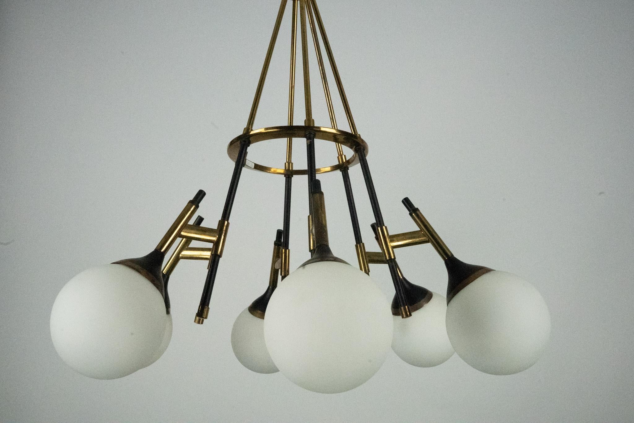 Auténtica lámpara de araña de mediados de siglo de Stilnovo, de los años 50. Con un llamativo diseño radial con globos de cristal esmerilado y brazos de latón, esta pieza encarna la elegancia y la innovación de la iluminación modernista italiana. En
