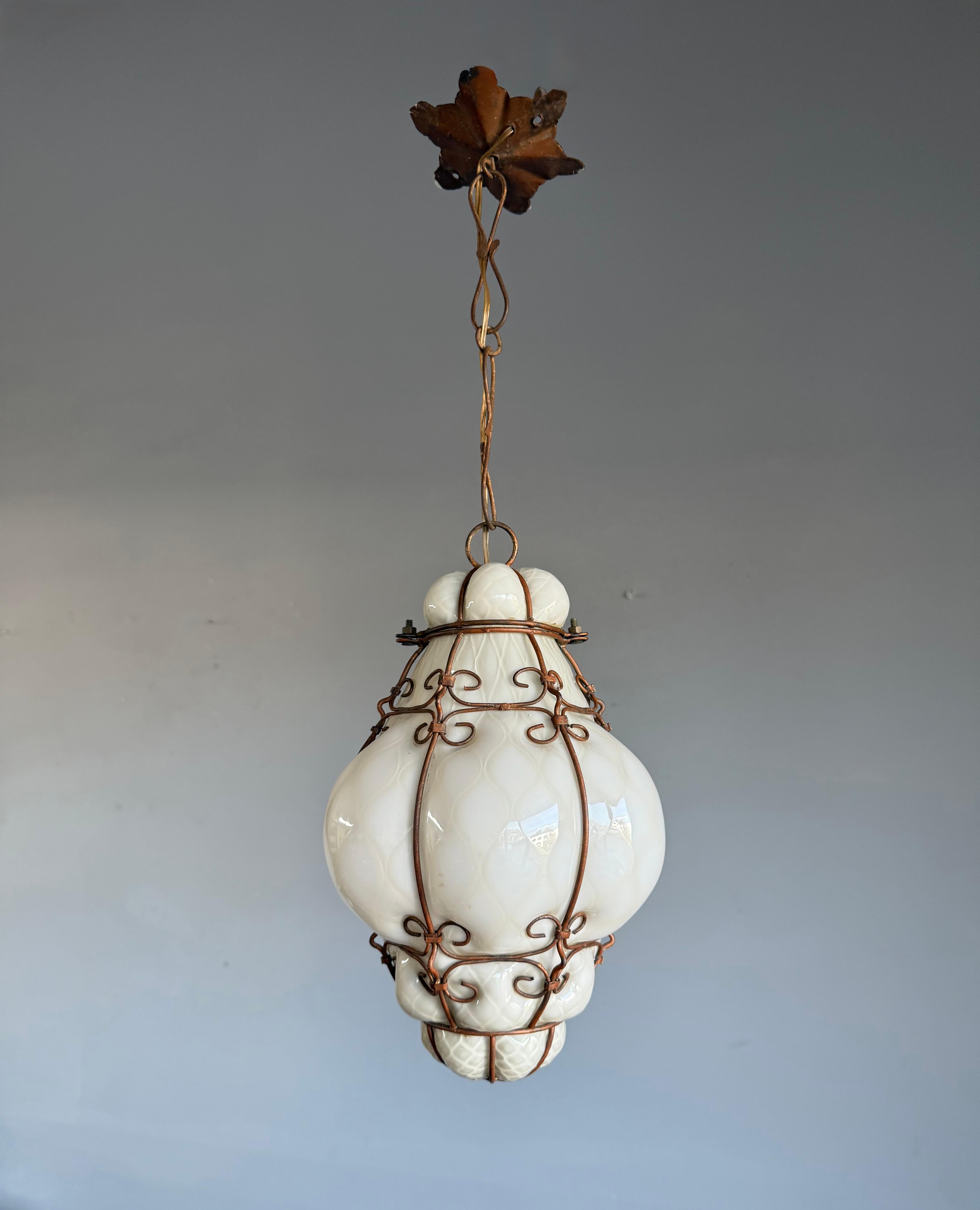 Suspension vénitienne de taille pratique en verre soufflé à la bouche dans une monture en métal bronzé.

Cette exquise lampe suspendue Murano des années 1950 est un chef-d'œuvre de l'artisanat italien, une composition sculpturale de verre opalin