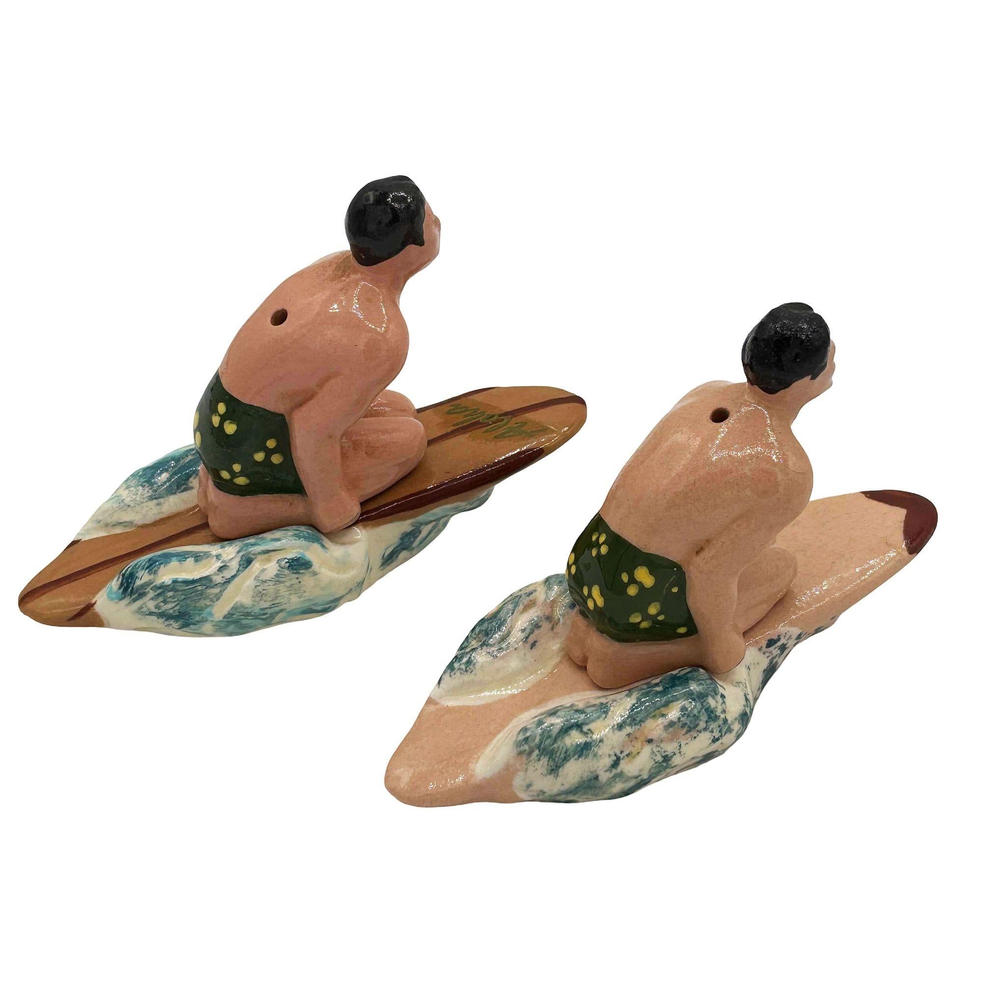 Seltenes Salz- und Pfefferstreuer-Set aus Keramik von Herman's aus dem Jahr 1951, ein hawaiianischer Surfer. Das Set besteht aus einem figurativen männlichen Salz- und Pfefferstreuer mit einem passenden Surfbrett, auf dem er perfekt sitzt. Sie sind