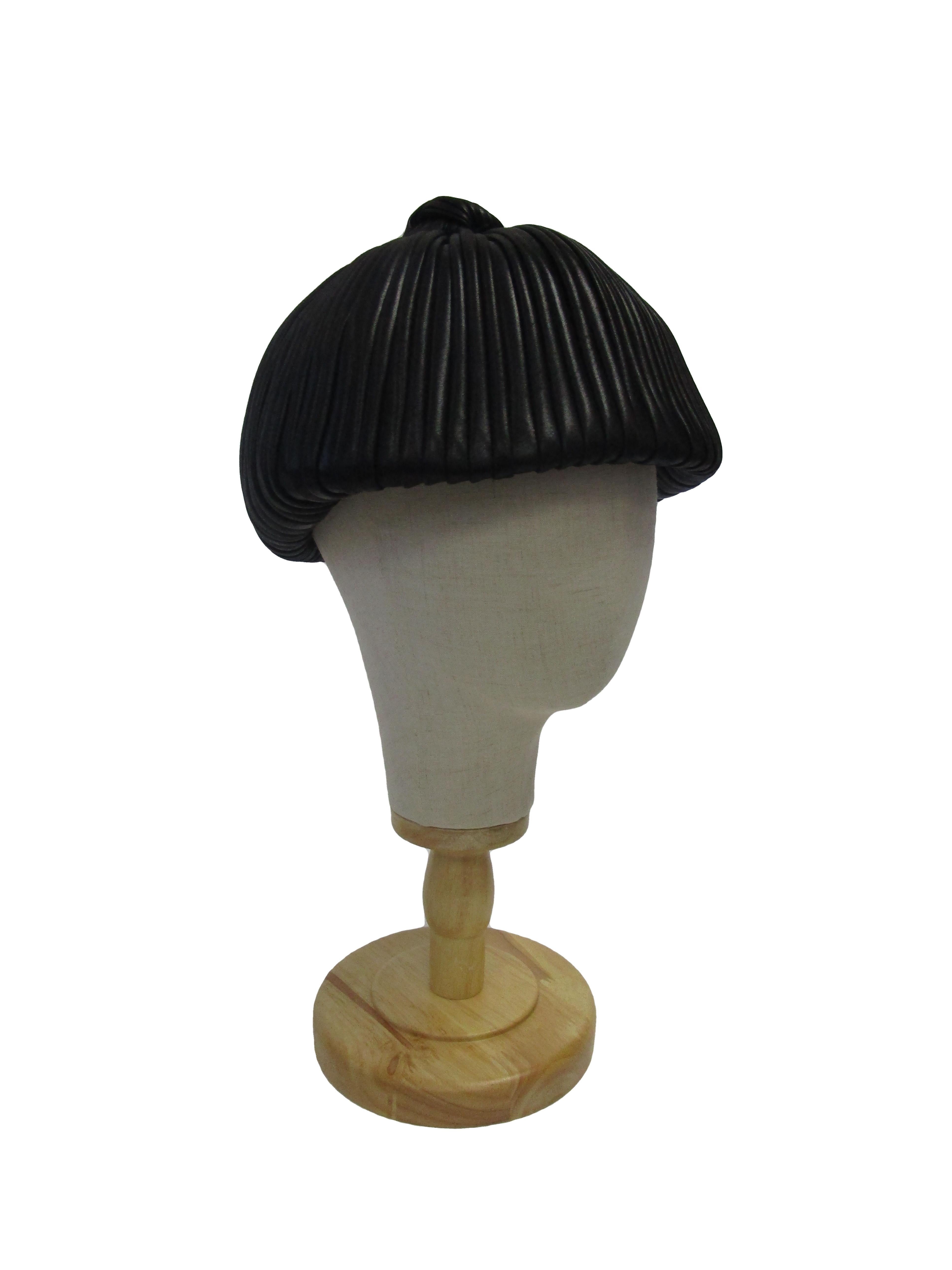 
Rare, Uniquely designed and executed, this captivating hat from the house of Dior was created during the years Marc Bohan was at the houses helm. 

This gorgeous chapeaux features a luscious silk that almost resembles leather. It is meticulously