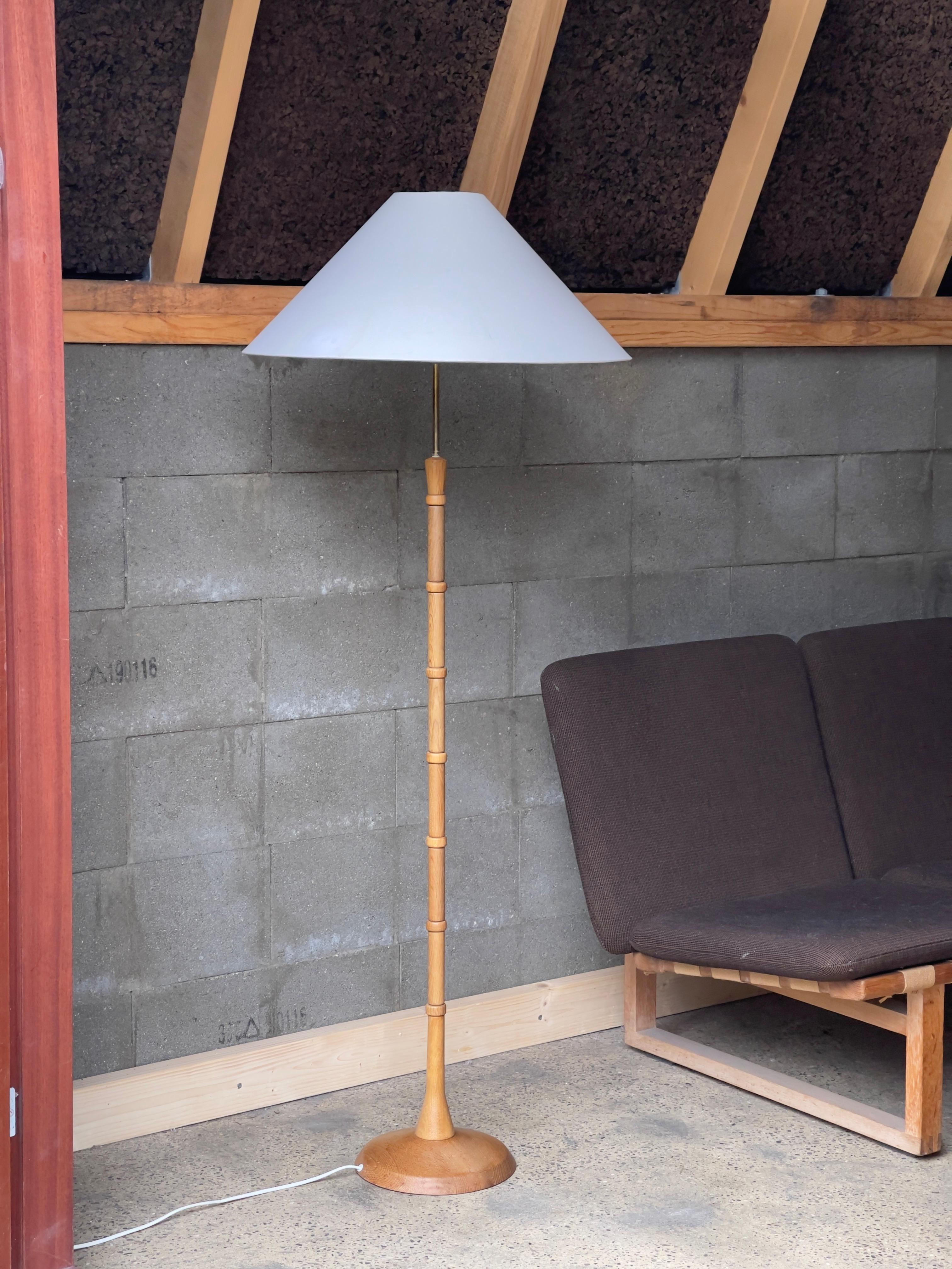 This rare Danish midcentury floor lamp from the 1960s stands as a testament to the exquisite craftsmanship and timeless elegance of Scandinavian design during that era. Crafted meticulously from solid oak and brass, its design epitomizes the fusion