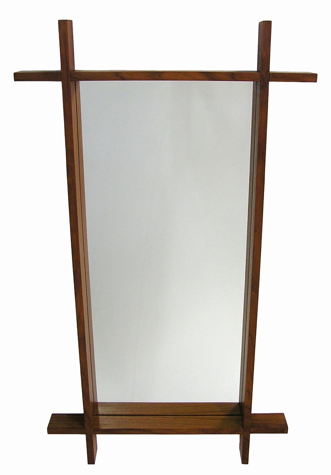 A stunning large Danish modern teak wall mirror from the 1960s. Features a uniquely crafted cross-sectioned solid teak frame and has been newly refitted with a 17 1/2