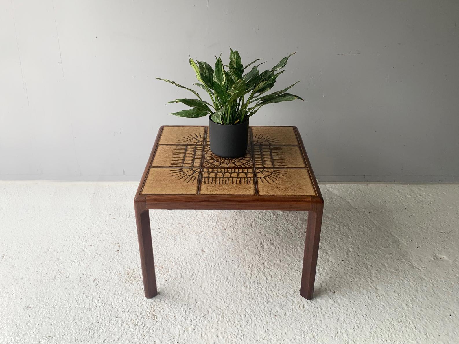 A high quality G Plan item. A square coffee table with solid, sculpted teak frame, inlaid with patterned ceramic tiles. In superb condition. 
(Partial remnant of G Plan red and gold sticker on base)

This Item can be delivered to an destination