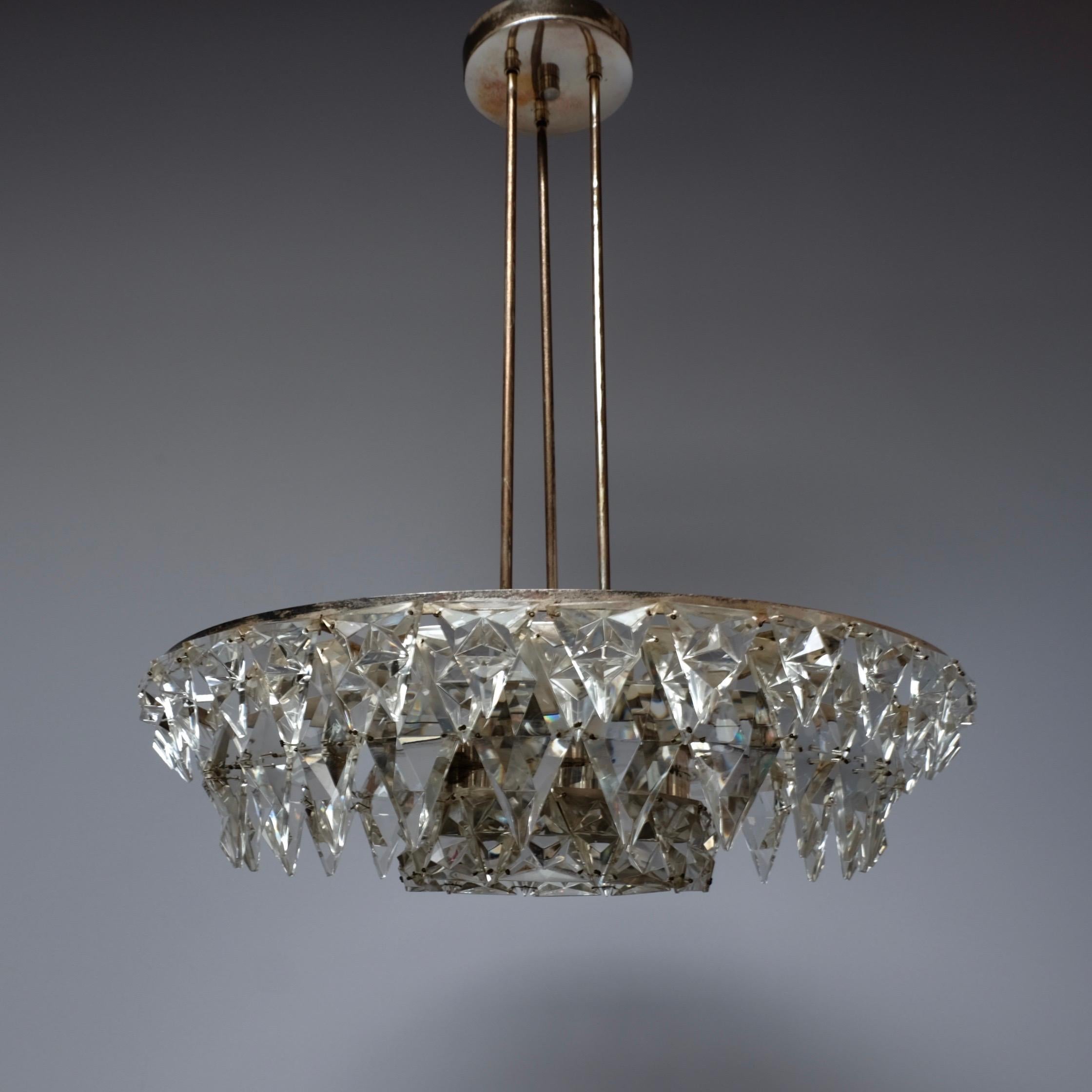 A rare and stunning silver brass plated and cut crystal glass icicle chandelier. Manufactured by Kinkeldey in Germany during the 1960s. The chandelier is suspended from three slim rods which attach to a circular ceiling rose. Two circular tiers of