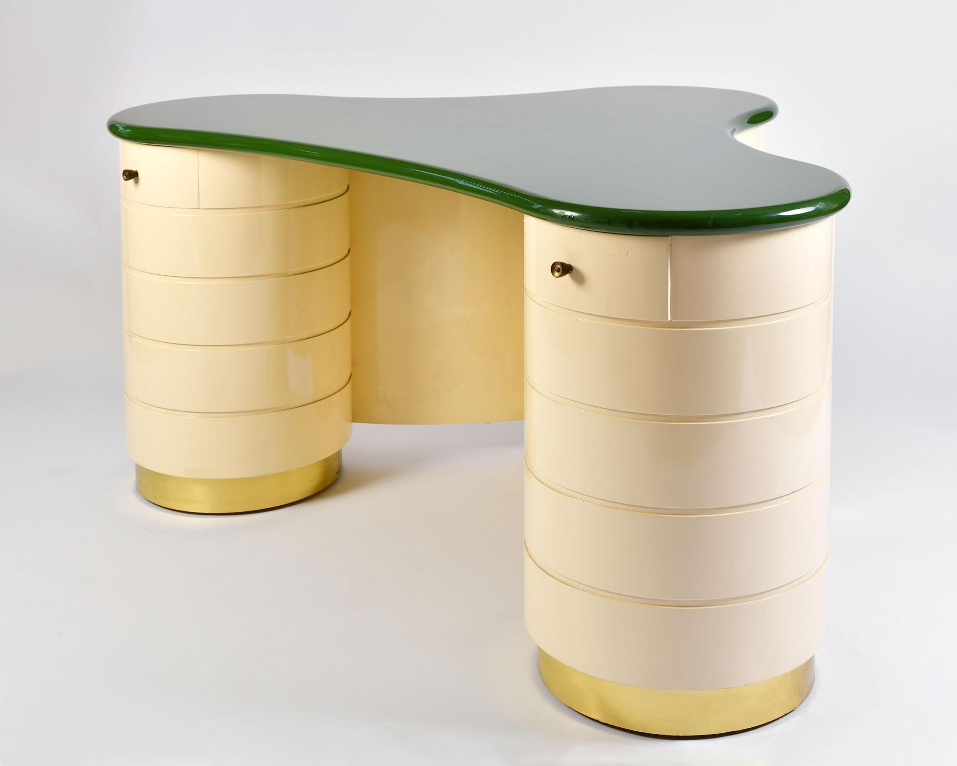 Ultra glamorous dressing-table/desk in a surrealist deco style. Three large cream lacquered circular pillars each with their own drawer stand on brass supports. In contrast a generous lacquered green top completes the dramatic effect.