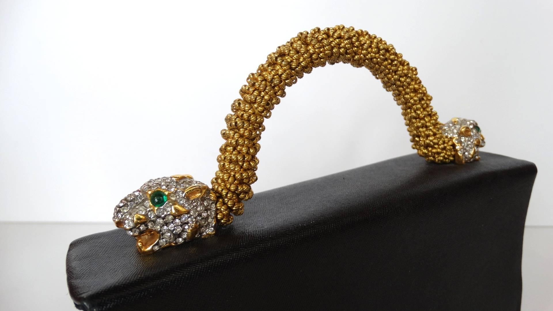 A fabulous 1960s designer vintage Kenneth Lane for Rosenfeld evening purse in black leather with gold tone hand beaded handle embellished with panther heads at either side, and bejeweled with hand set clear round cut cougar diamente  with green