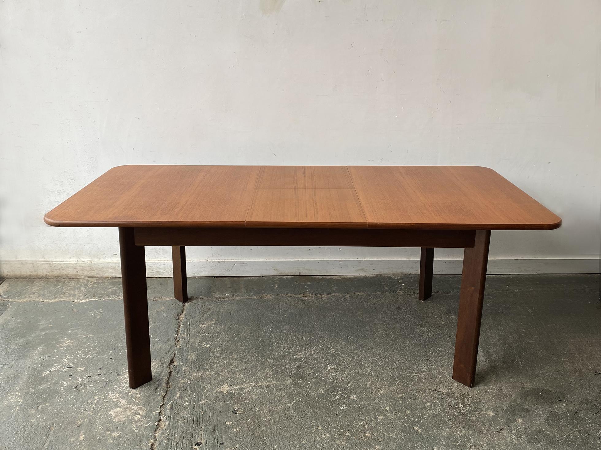 A G plan extending dining table, with a design that is not typical  of the G Plan style.
G Plan collaborated with Danish designers including Kofod Larsen, and this was probably the design of this table originated.

It is a substantial table, with