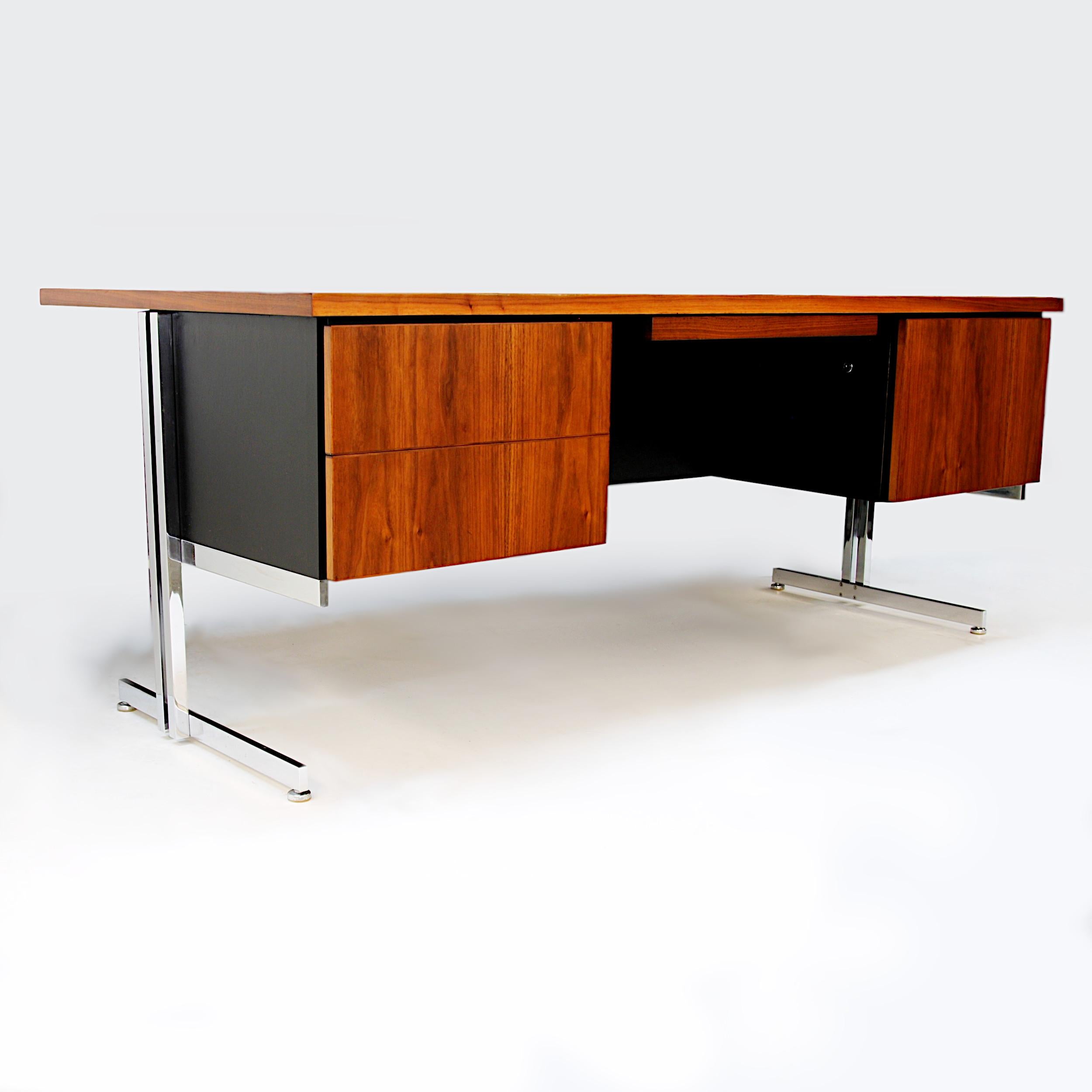 Rare executive desk designed by Hugh Acton for the Vecta Contract Co. Desk features matched-grain walnut cabinetry cantilevered over the Classic Acton chromed-steel base. With its wonderful, architecturally-inspired, Minimalist design, this would