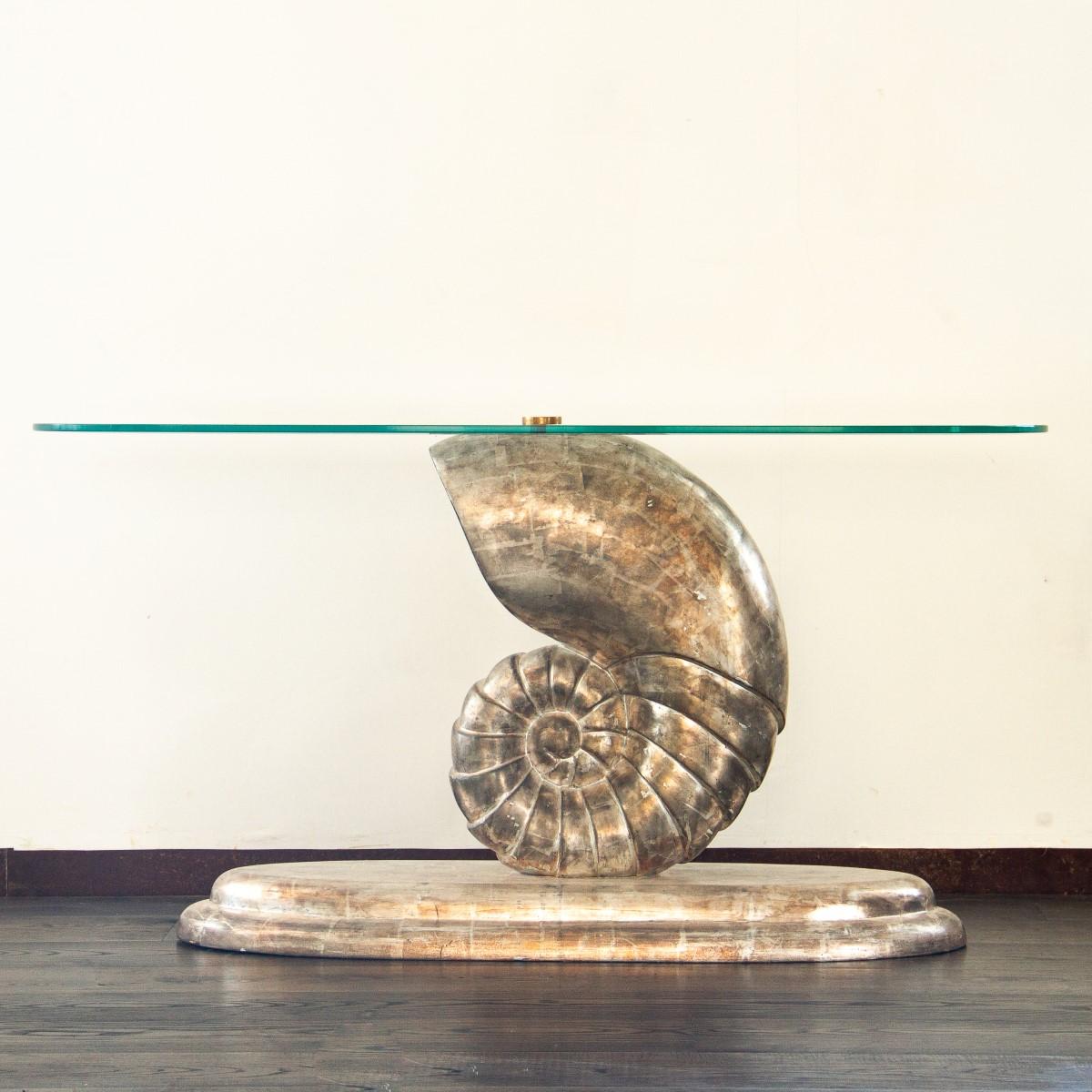 A rare 1960s nautilus shell console table, carved in plaster with stunning detail finished in white gold leaf surmounted by an oval glass top and brass hardware. A truly distinctive look that would work extremely well in a coastal interior or as a