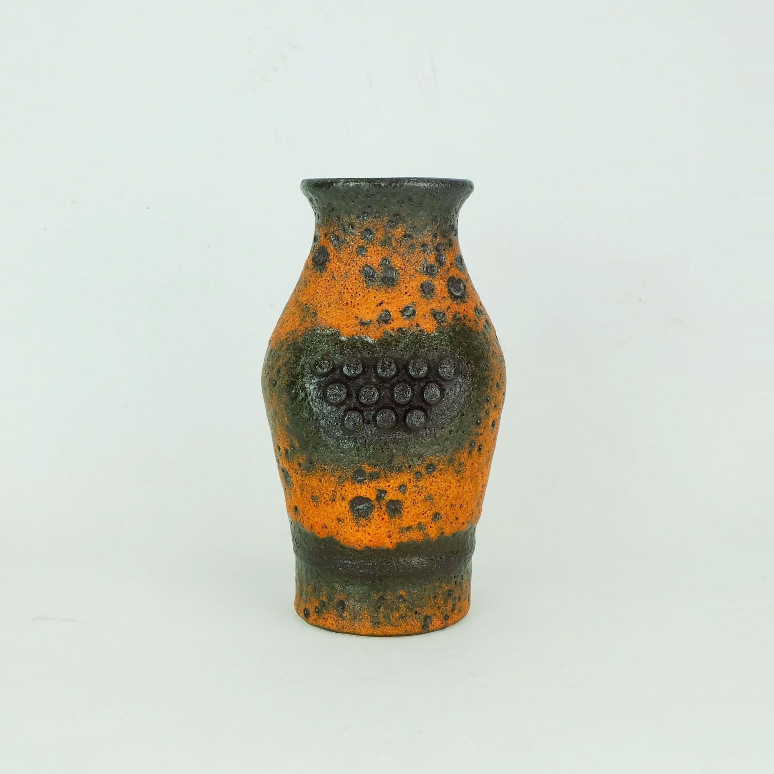 Vaso della Germania occidentale prodotto da u-Keramik negli anni '60. Modello 'Robot' con smalto di lava grassa in arancione e marrone scuro e decoro a pomello su entrambi i lati.

Altezza 7 9/10