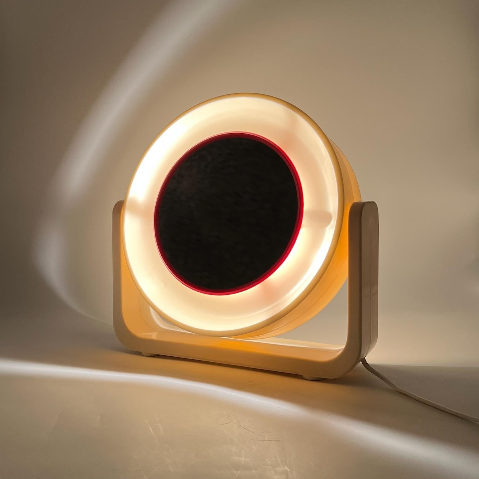Discover the timeless elegance of this very rare space age mirror with light, produced by Allstar in West Germany during the 1960s. This beautifully crafted piece, with its elegant cream hue and red accents, offers a unique combination of style and