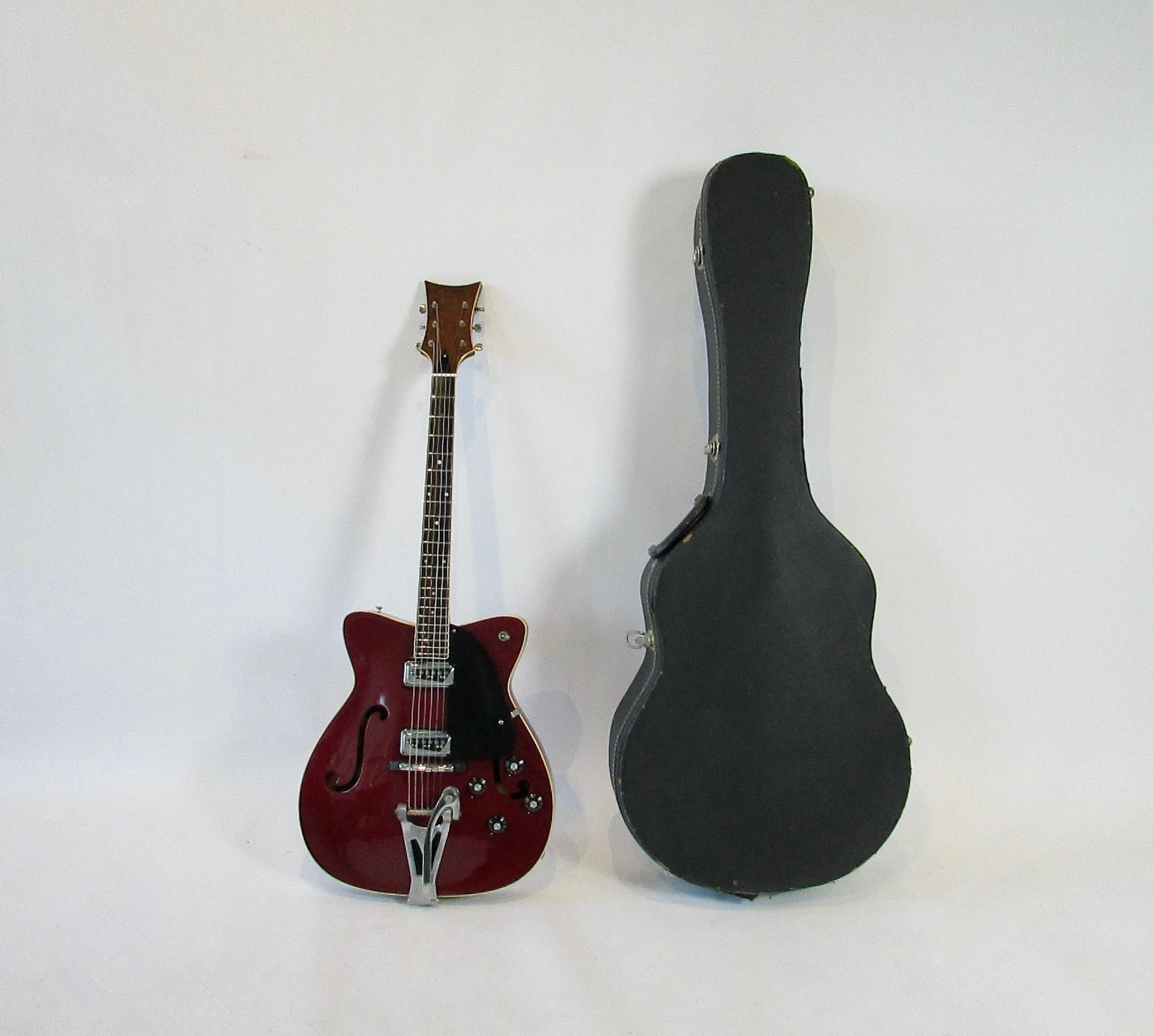 C.F. Martin GT-75 electirc guitar .1966, hollow-body, arch-top electric guitar.  Serial # 215489 Burgundy with cream banding . Guitar shows wear and use . Some minor chips pick wear shown above the upper F hole . Headstock shows an older repair but