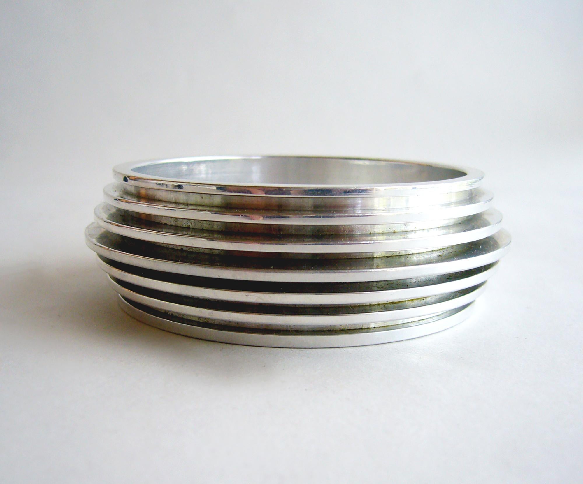 Rare, machined aluminum bracelet designed by American jeweler Chris Den Blaker.  Den Blaker collaborated with famed clothing designer Rudi Gernreich in the 1970's which resulted in a small group of evening dresses with attached aluminum jewelry.  I