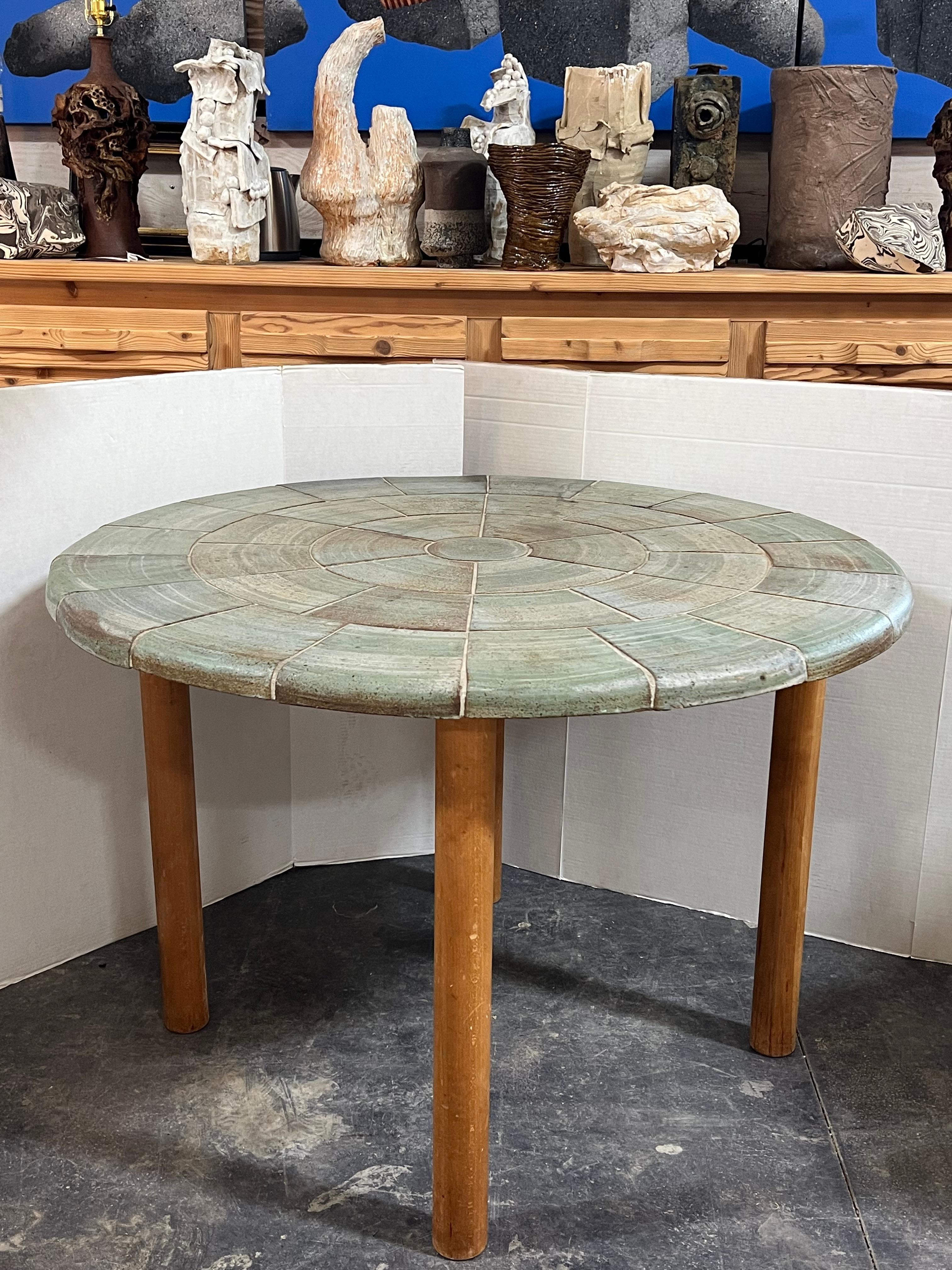 Rare 1970’s Danish round dining table with stoneware top and wood base. Designed by Britt Sallingboe. Signed 